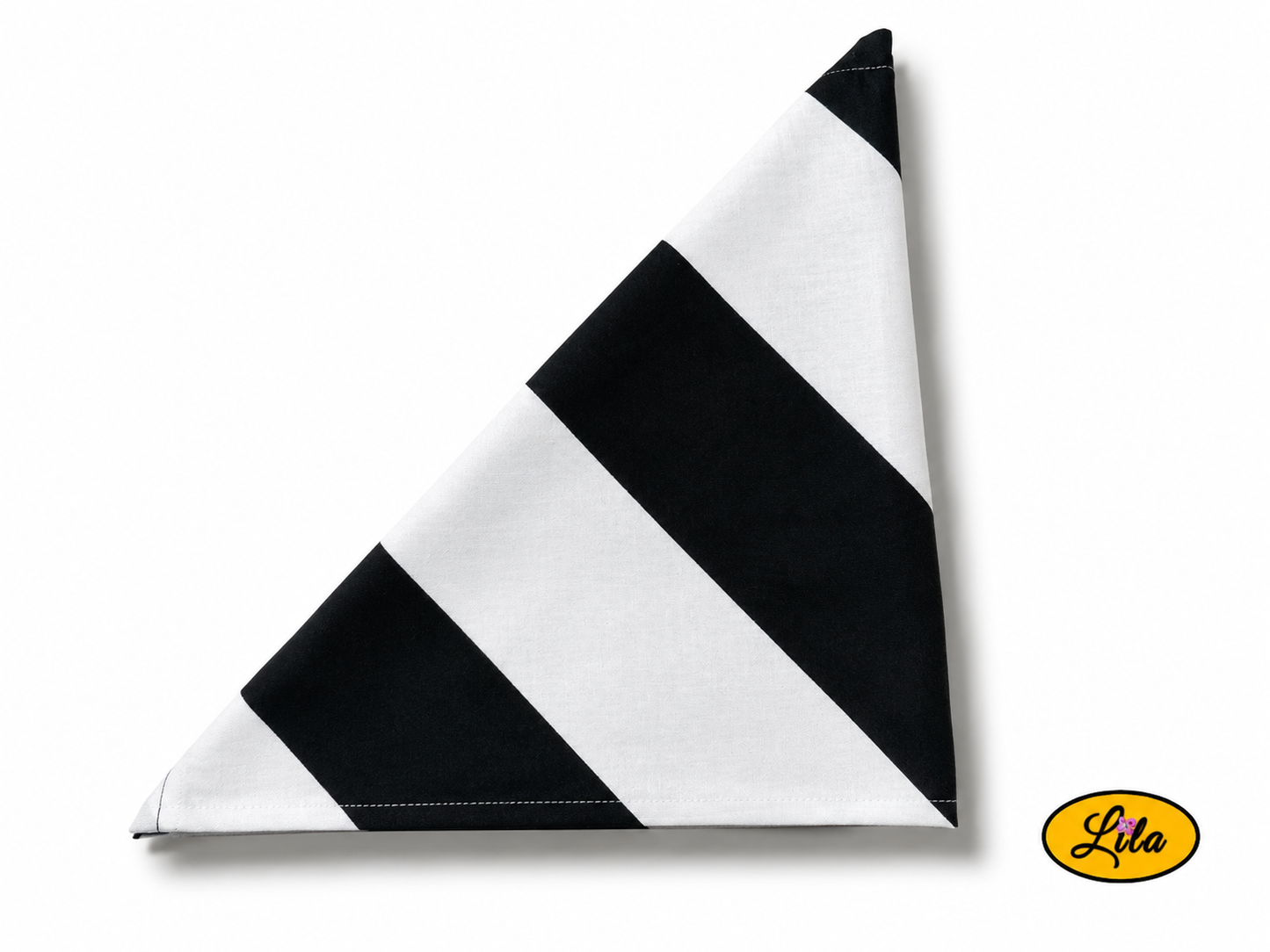 Bandana noir à larges rayures blanches plié en triangle vu de haut sur fond clair mettant en valeur le motif graphique du tissu