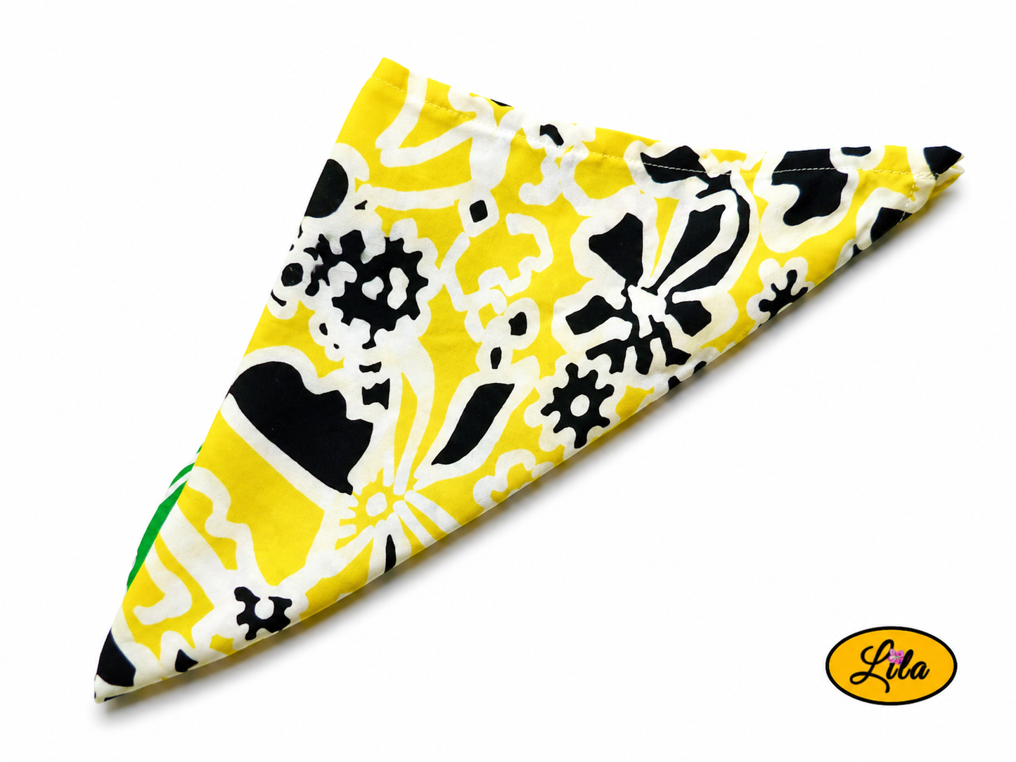 Bandana vert et jaune à motifs floraux vintage plié en triangle avec le côté jaune visible vu de haut sur fond clair style rétro et artisanal