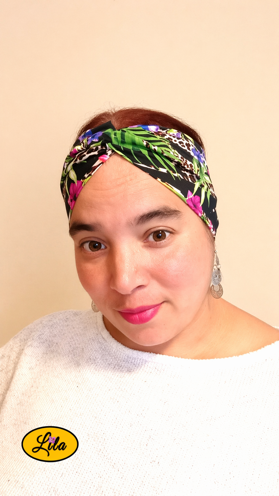 Bandeau en tissu à fleurs tropicales porté de face tête légèrement inclinée vers la gauche avec noeud au-dessus