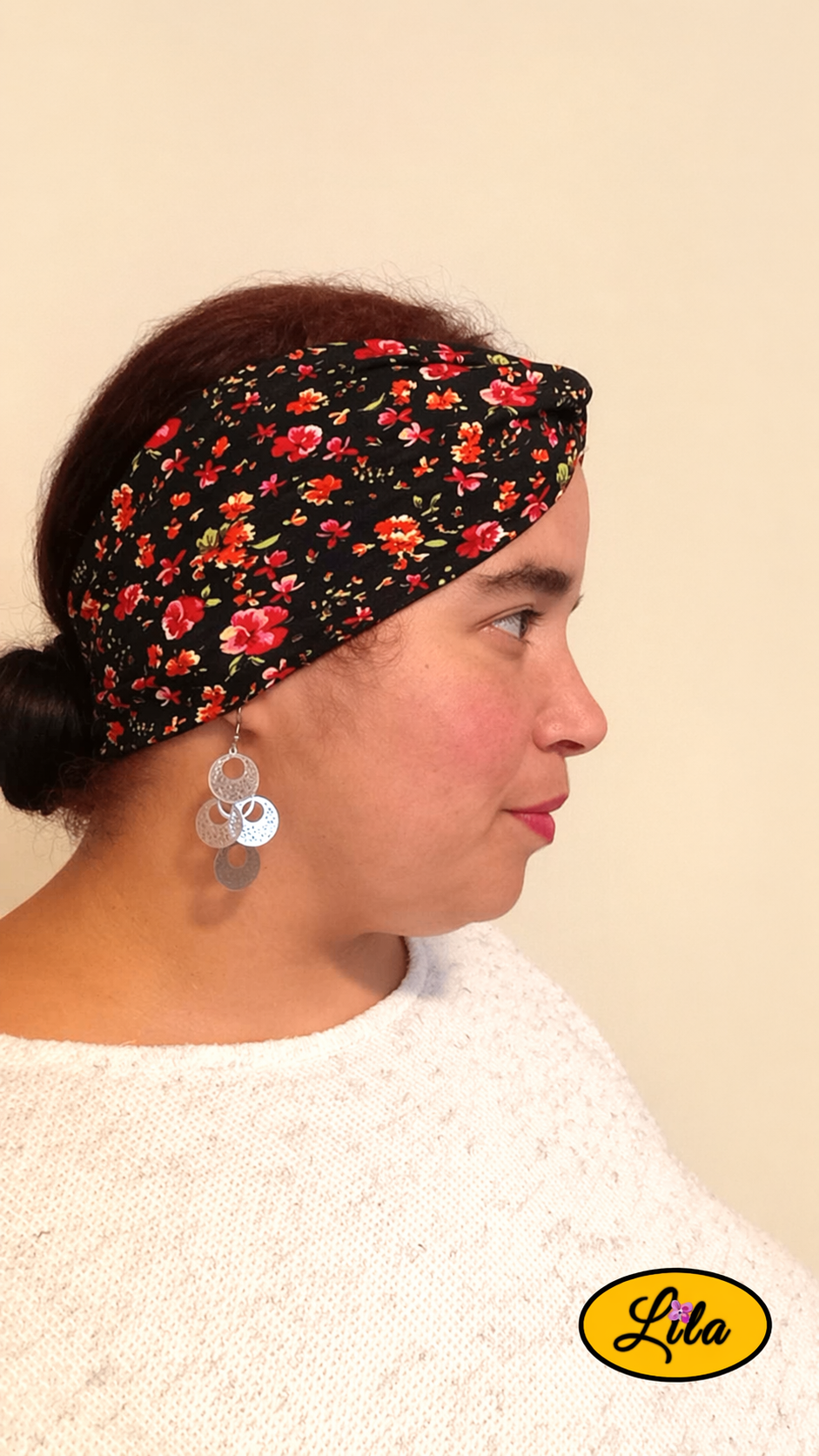Bandeau en tissu noir à petites fleurs porté profil droit avec noeud au-dessus de la tête