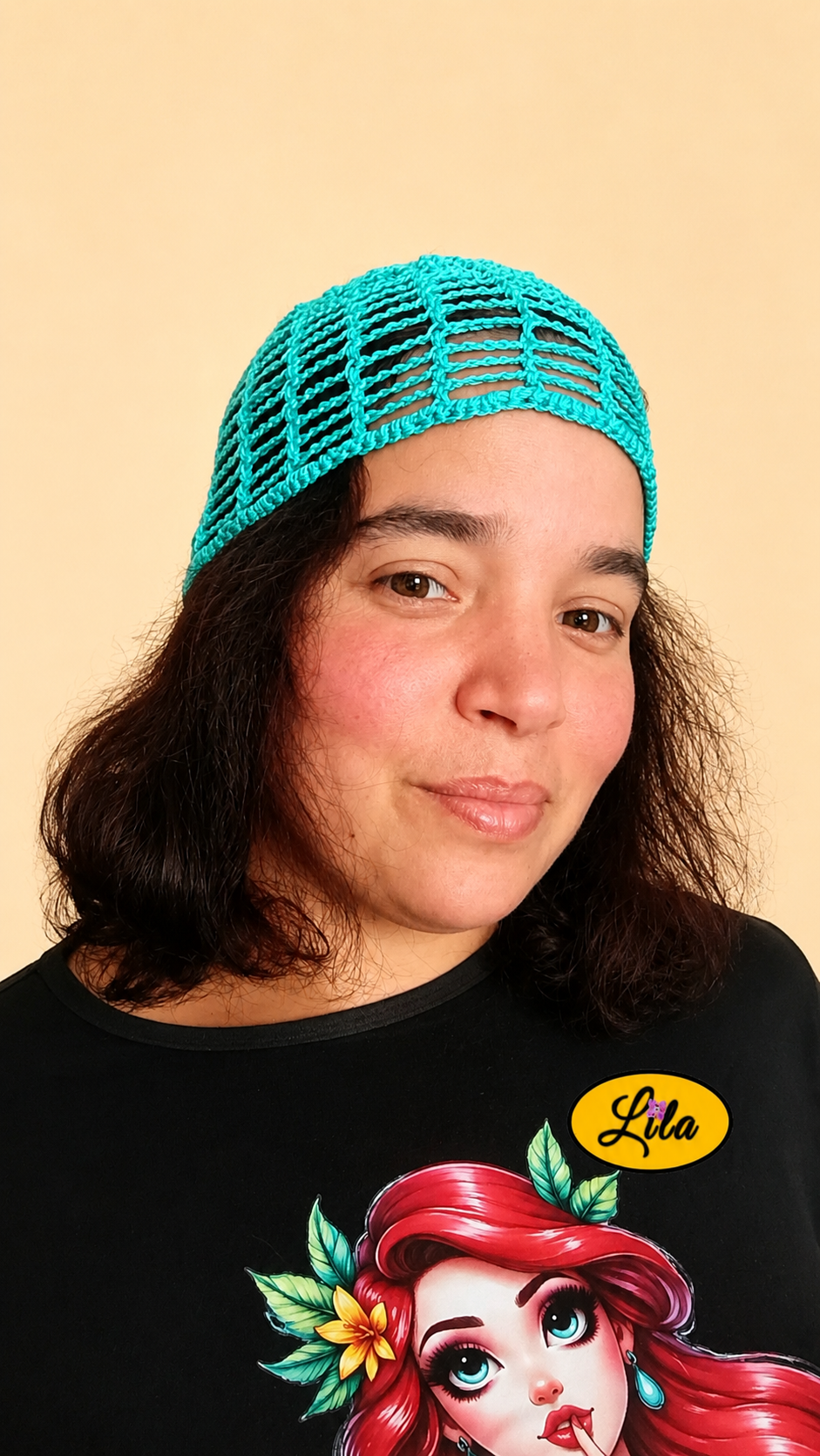 Bonnet d'été en crochet ajouré vert turquoise porté par un mannequin de profil droit avec les cheveux lâchés mettant en valeur son style bohème, sa légèreté et son crochet fait main