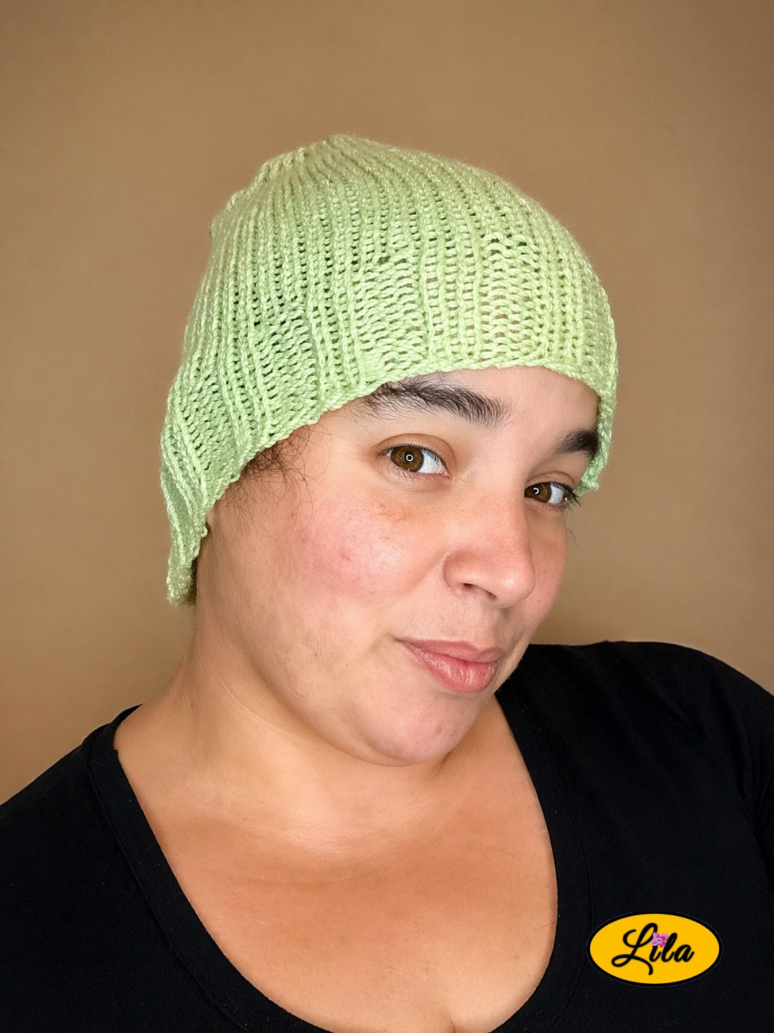 Bonnet en laine vert clair pailleté porté profil droit avec cheveux à l’intérieur du bonnet