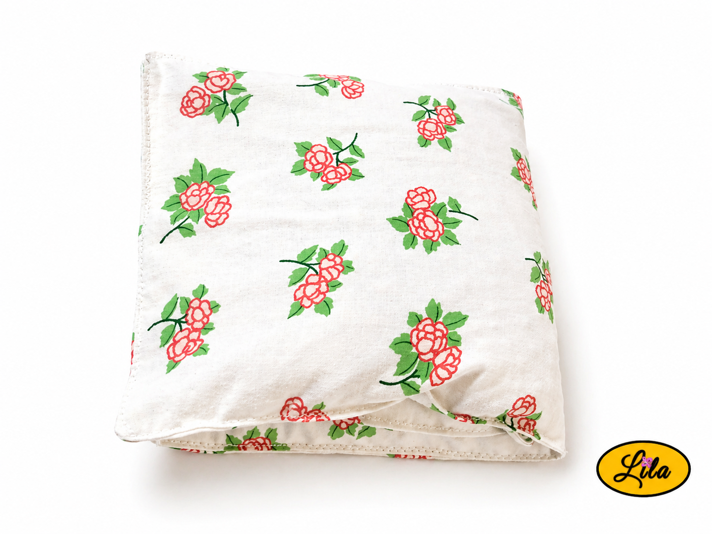 Bouillotte XL blanche fleurie réalisée dans un ancien drap de lit recyclé remplie de noyaux de cerise pliée en trois vue de haut sur fond blanc style naturel et chaleureux