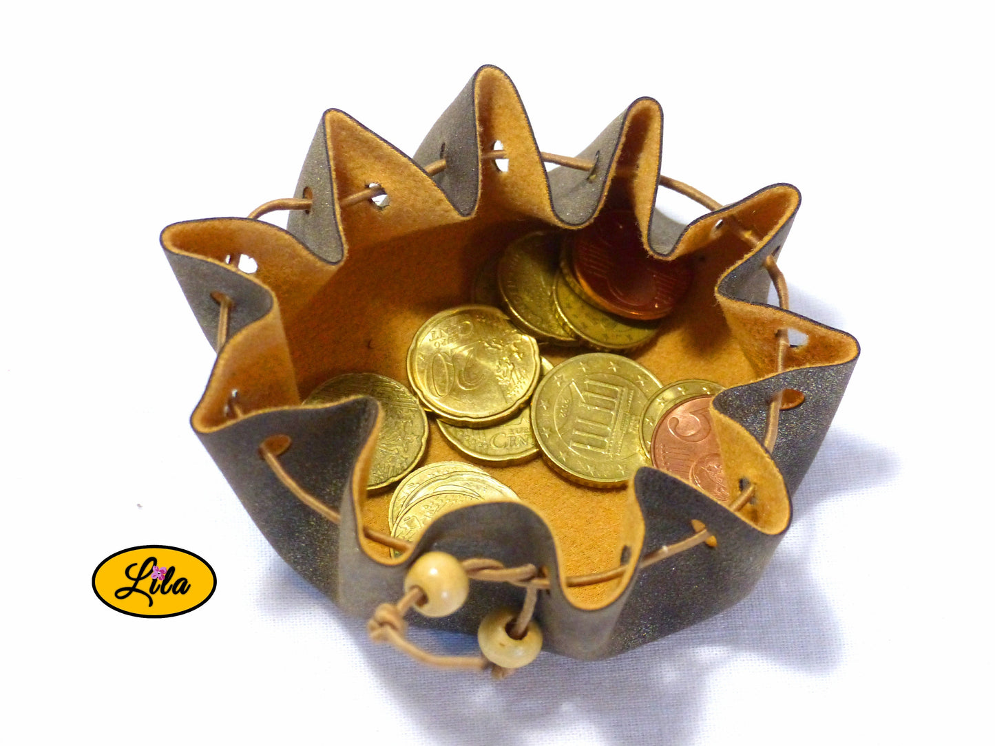 Bourse ronde brune effet doré en simili cuir ouverte vue de haut avec pièces de monnaie visibles à l’intérieur sur fond blanc style bohème et artisanal