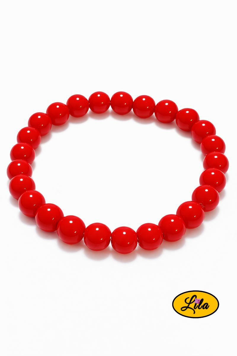 Bracelet en fausses perles rouges sur fond blanc vue produit