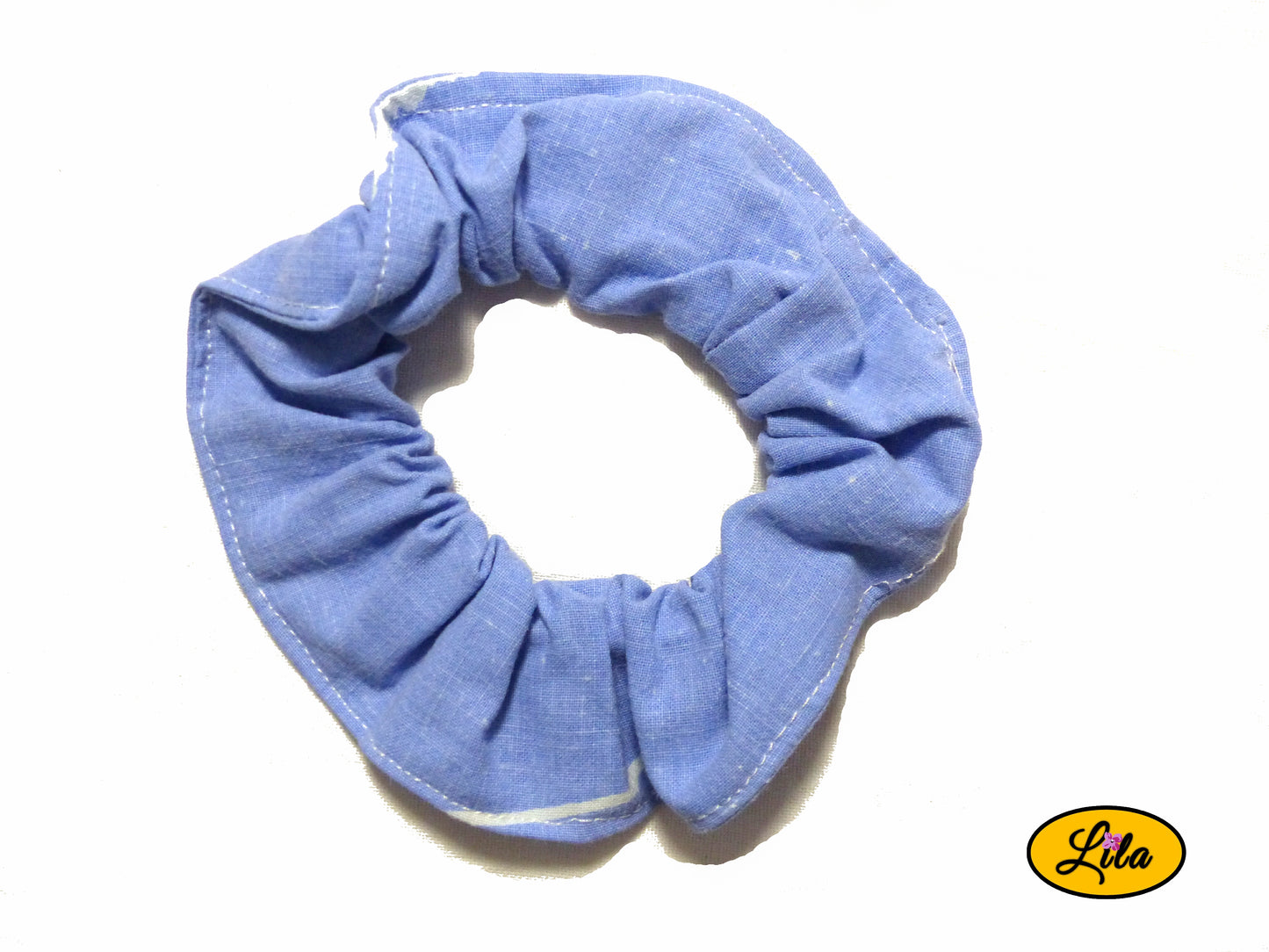 Chouchou pour cheveux en tissu bleu avec motifs de lignes blanches présenté sur fond blanc style moderne et artisanal
