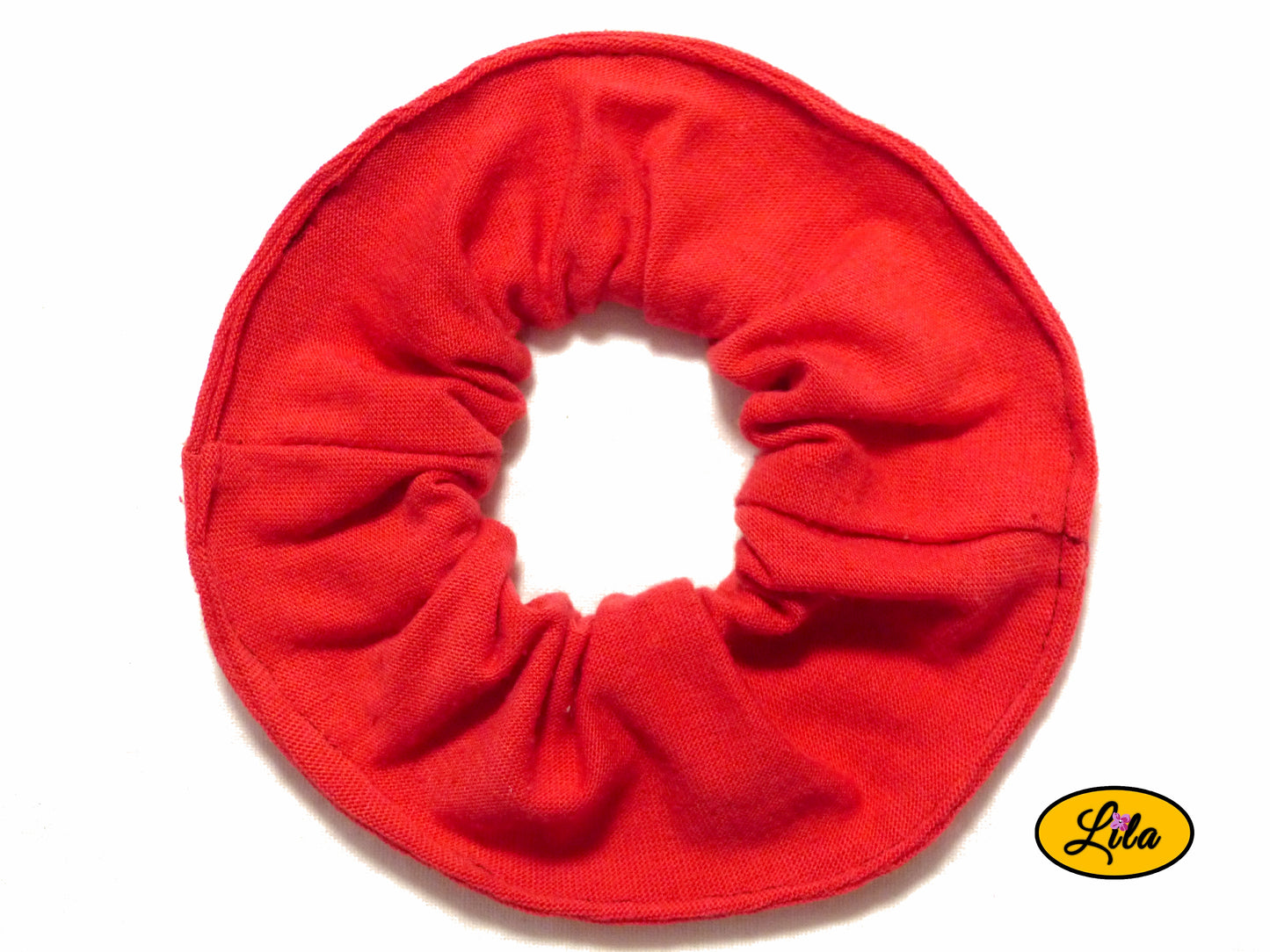 Chouchou pour cheveux en tissu rouge uni présenté sur fond blanc style coloré et artisanal