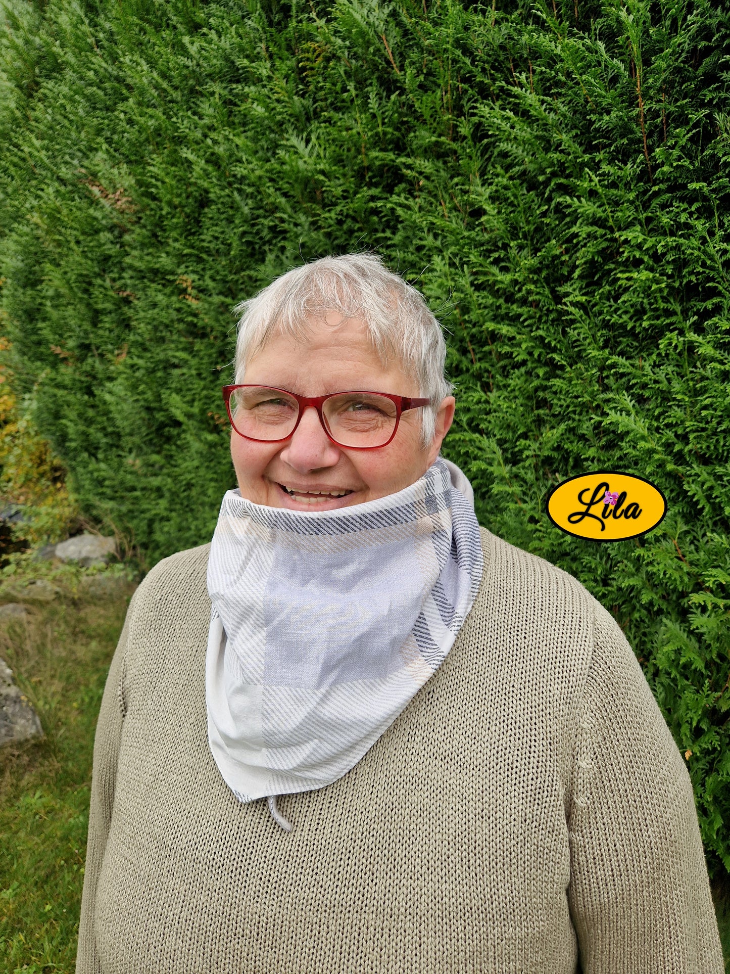 Gros plan sur le foulard triangulaire vintage à lignes brun et gris porté fermé avec nœud caché sous la pointe style rétro et cocooning
