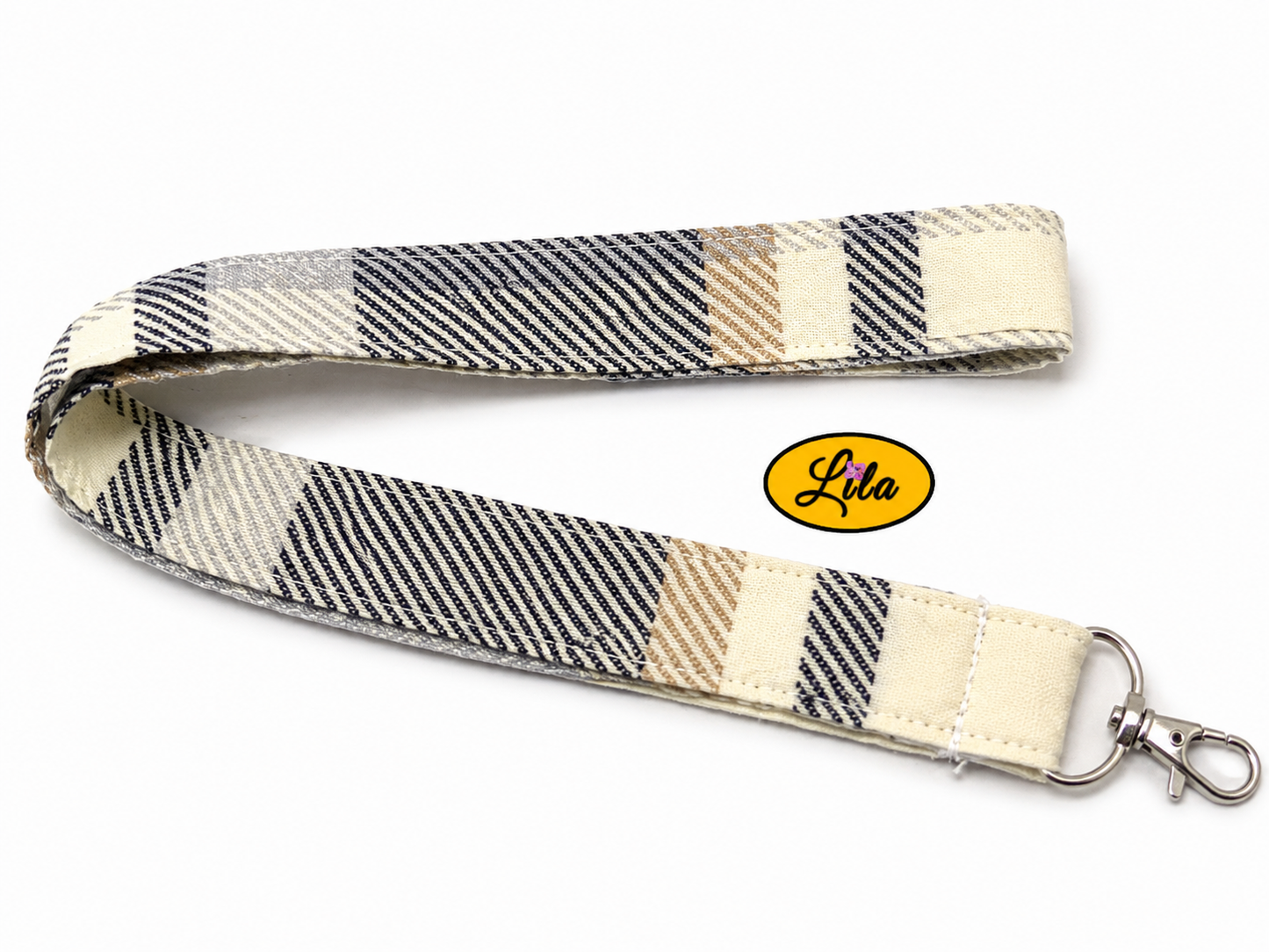 Porte-badge en tissu vintage brun à lignes légèrement replié en deux sur fond blanc avec mousqueton métallique style pratique et rétro