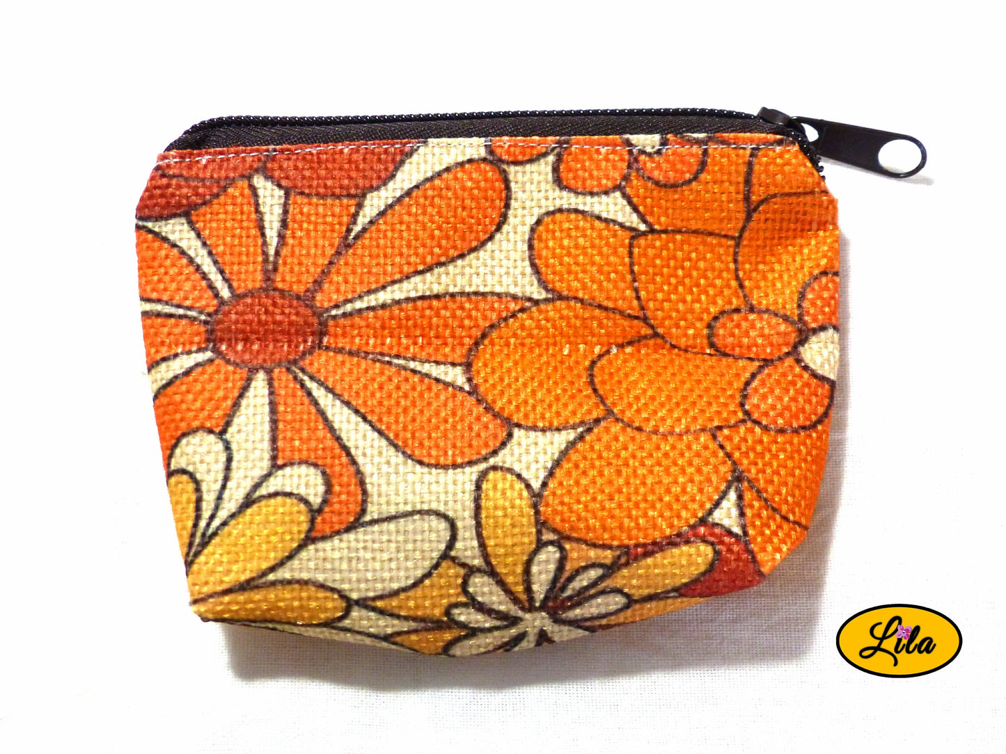 Porte-monnaie en tissu vintage orange fleuri issu d’une ancienne nappe avec fermeture éclair brune posé de face vue de haut sur fond blanc style bohème et artisanal