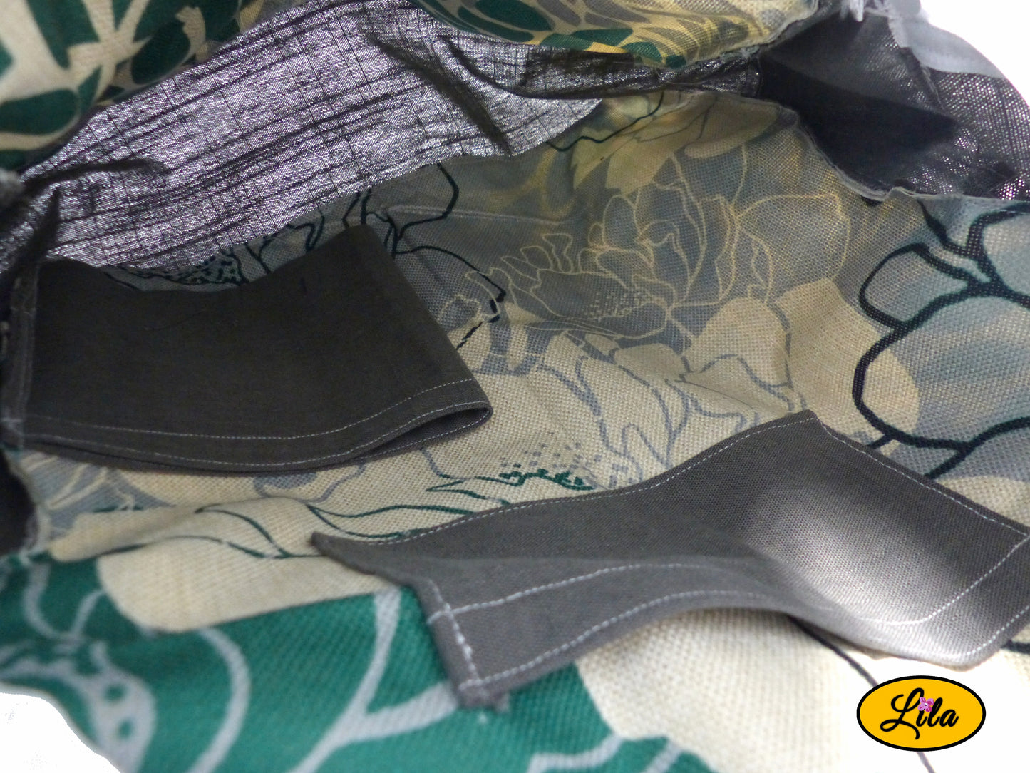 Intérieur d’un sac à dos artisanal avec doublure florale graphique, poche de rangement intégrée et porte-bouteille gris visible style pratique et organisé