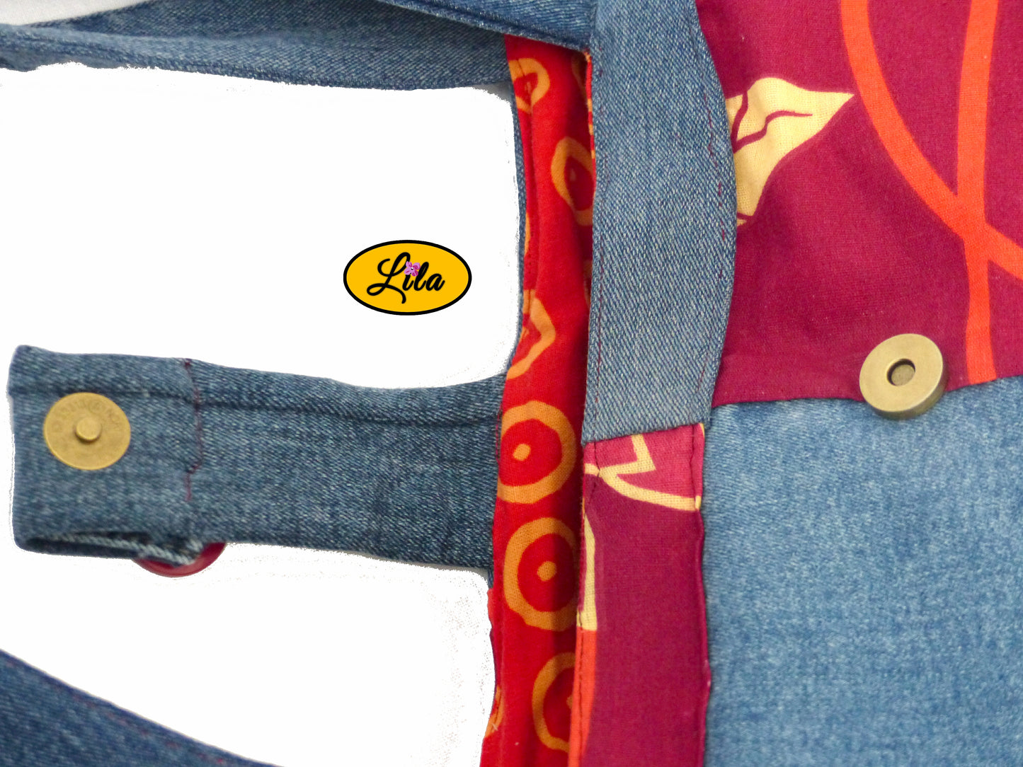 Vue de haut du sac épaule en jeans et tissu rouge fleuri avec attache pression ouverte détail ouverture et rangement