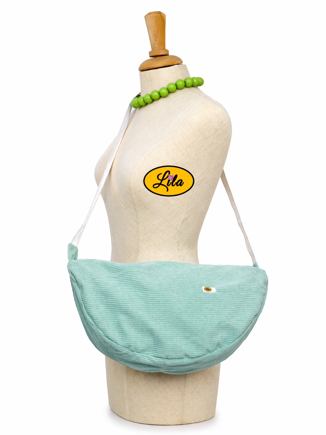 Sac Luna en velours côtelé vert menthe avec anse blanche porté sur mannequin de profil montrant la longueur de l’anse