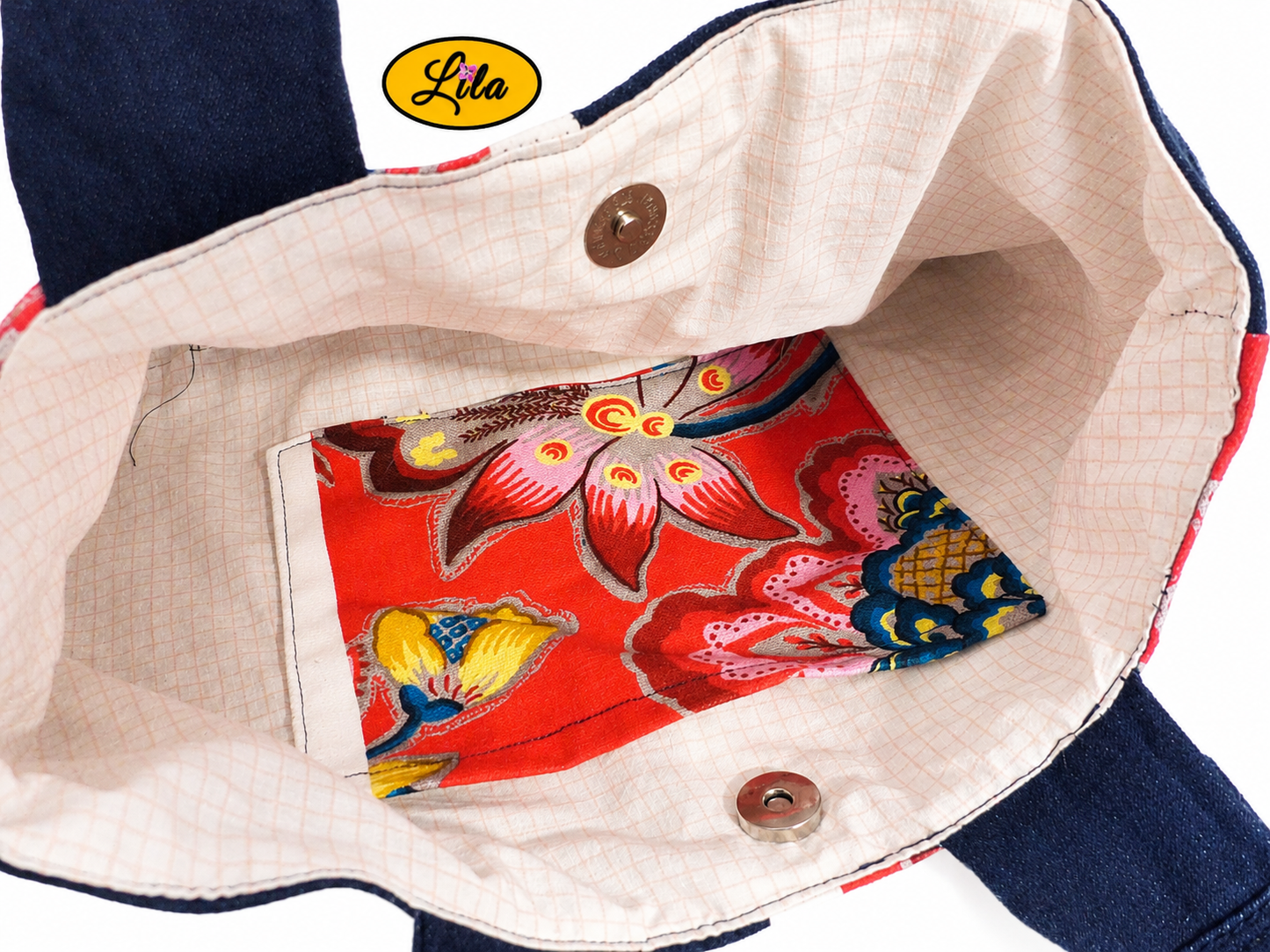 Vue rapprochée de l’intérieur du sac à main en jeans et tissu floral rose avec doublure blanche quadrillée rose, poche intérieure assortie et fermeture par attache pression