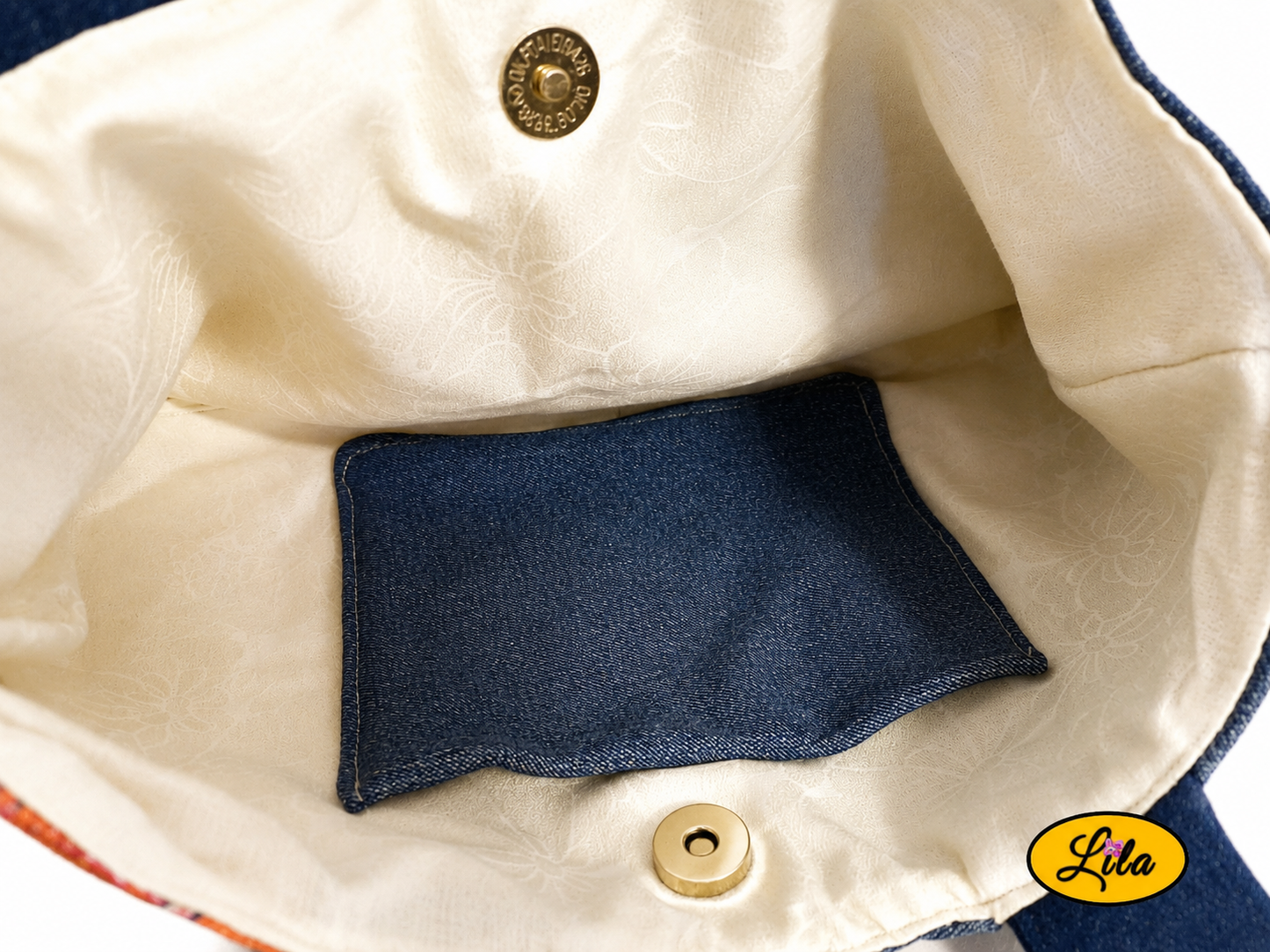 Vue intérieure du sac à main en jeans et ancienne nappe vintage orange fleurie avec doublure blanche, poche intérieure en jeans et fermeture par attache pression