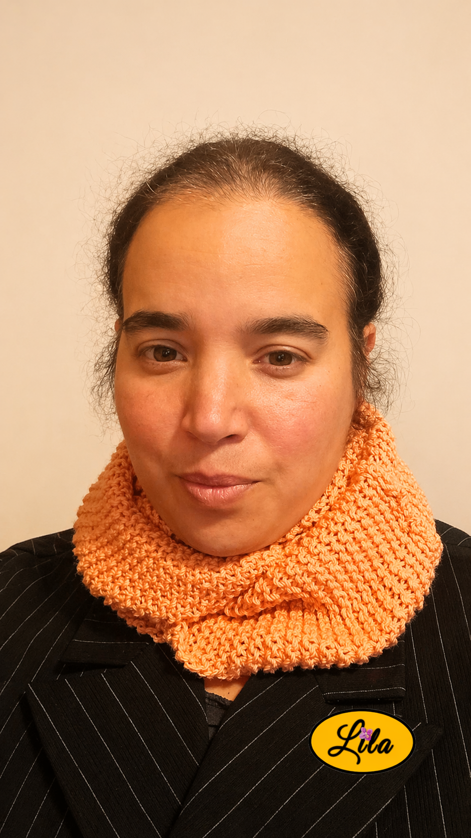 Snood en laine rose saumon porté par une femme vue de face style doux et hivernal