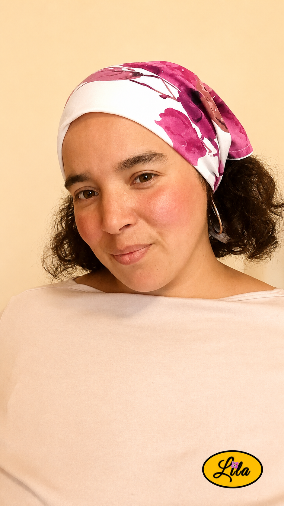 Bandana blanc à fleurs roses et inscriptions grises avec cachet Nature porté dans les cheveux par une femme de profil gauche aux cheveux détachés sur fond crème style champêtre et féminin