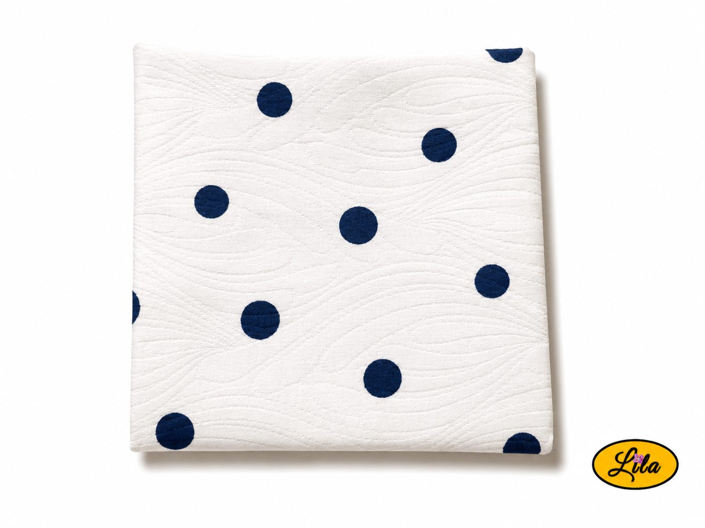 Bandana blanc à pois marine plié en carré vu de haut sur fond clair mettant en valeur les motifs à pois et le tissu