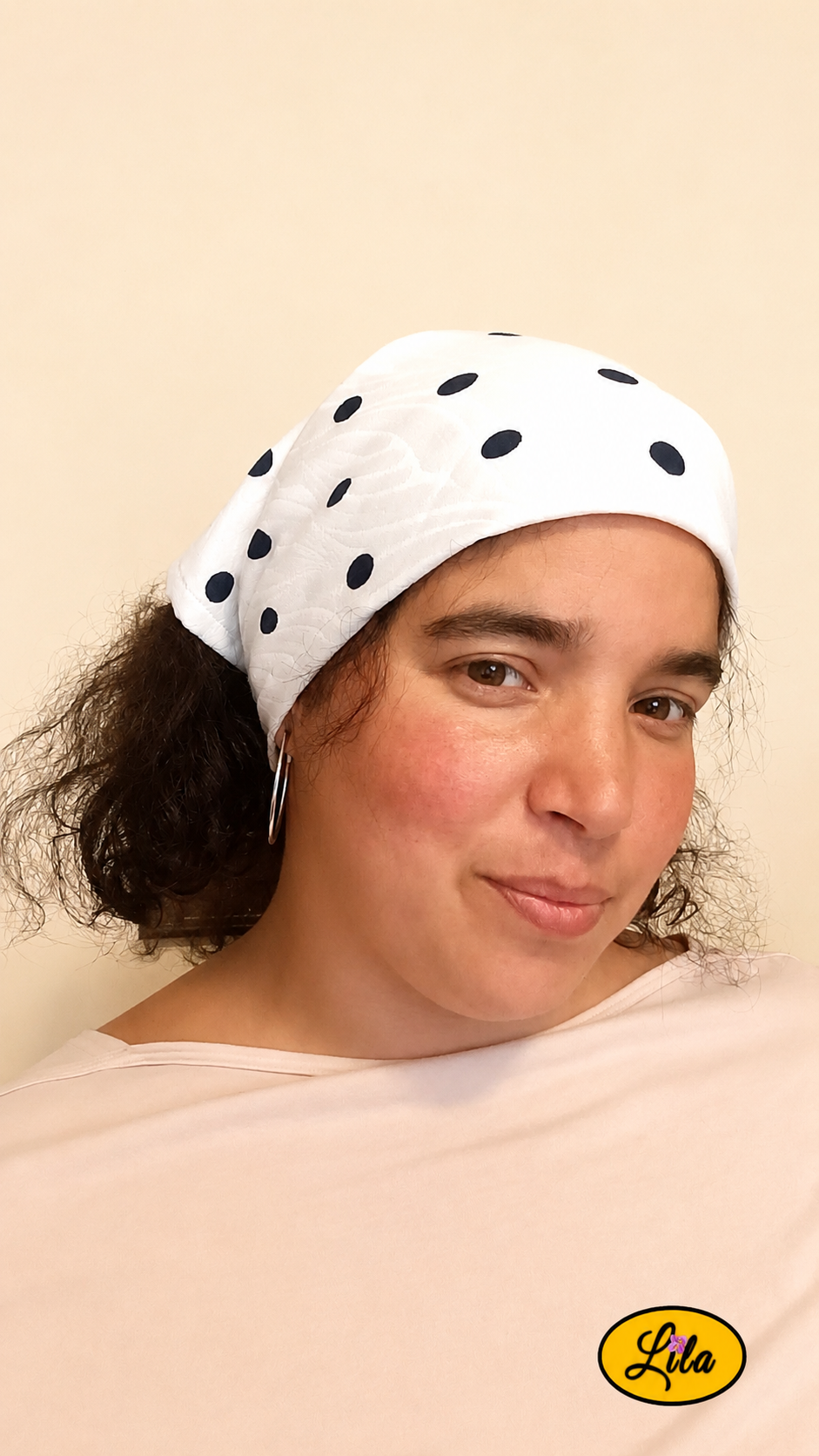 Bandana blanc à pois marine porté dans les cheveux par une femme de profil gauche aux cheveux détachés sous le bandana style marin et féminin