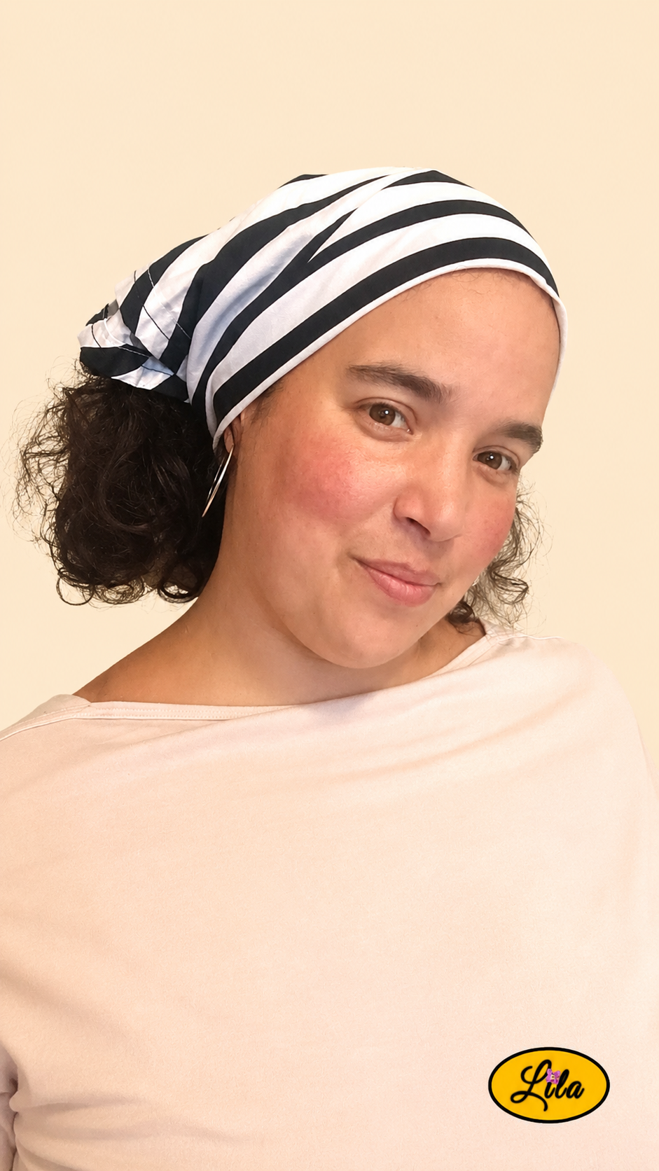 Bandana blanc à rayures noires porté dans les cheveux par une femme de profil droit avec les cheveux lâchés sous le bandana style graphique et intemporel