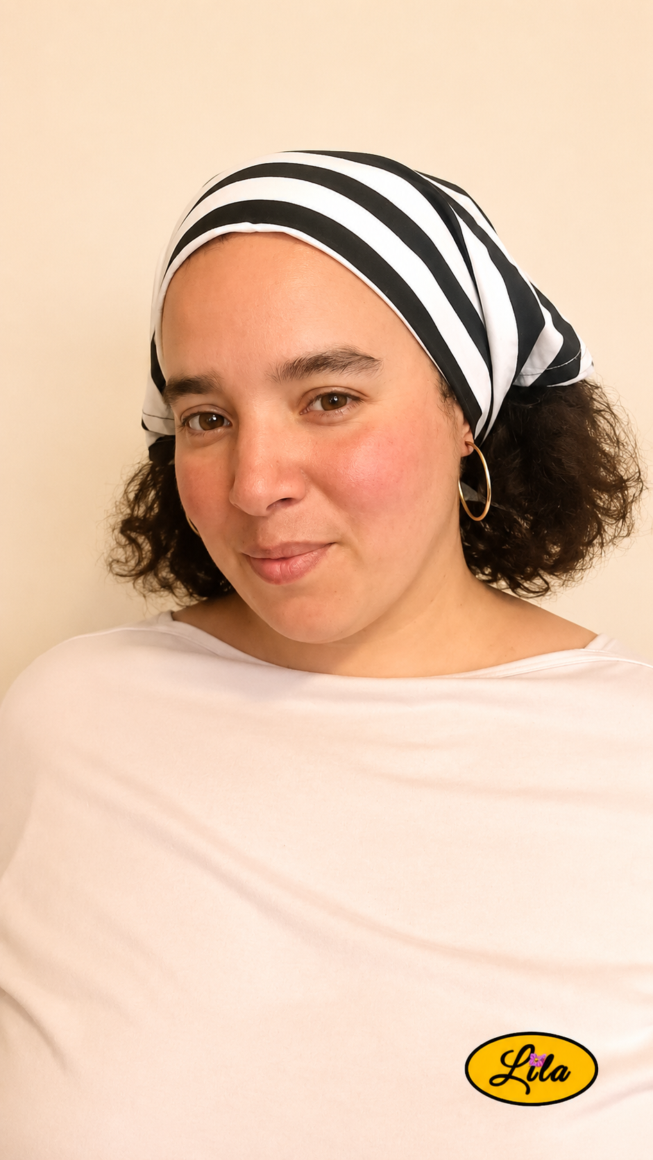 Bandana blanc à rayures noires porté dans les cheveux par une femme de profil gauche avec les cheveux lâchés sous le bandana style marin et tendance