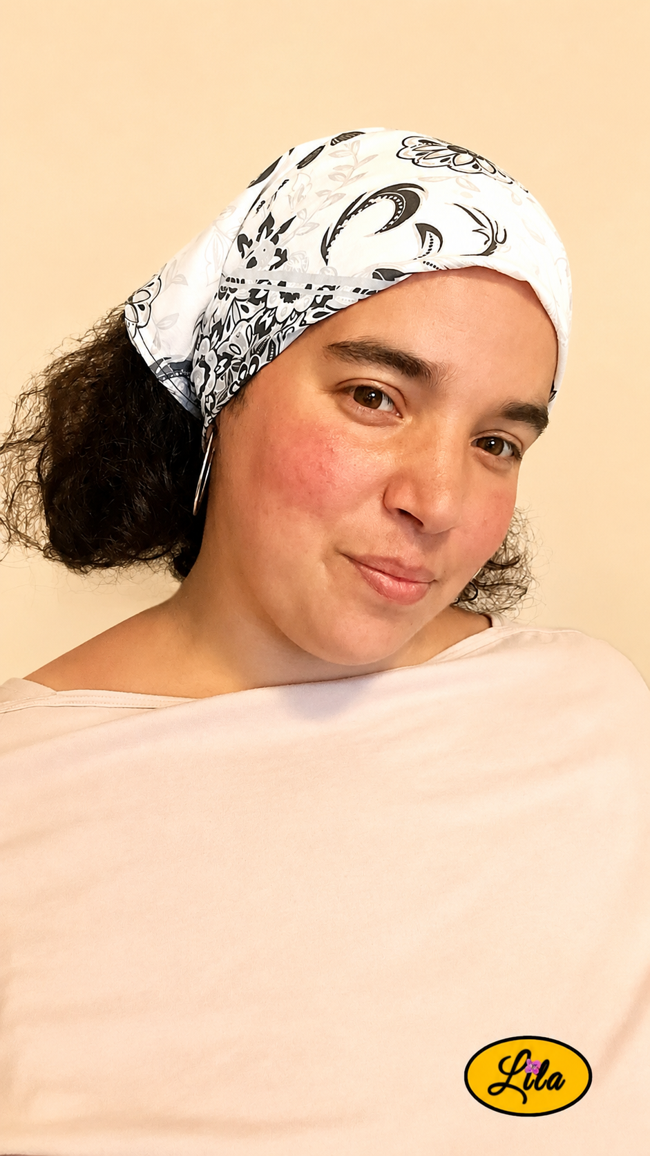 Bandana noir et blanc à motifs baroques porté dans les cheveux par une jeune femme légèrement de profil droit avec les cheveux lâchés style chic et intemporel