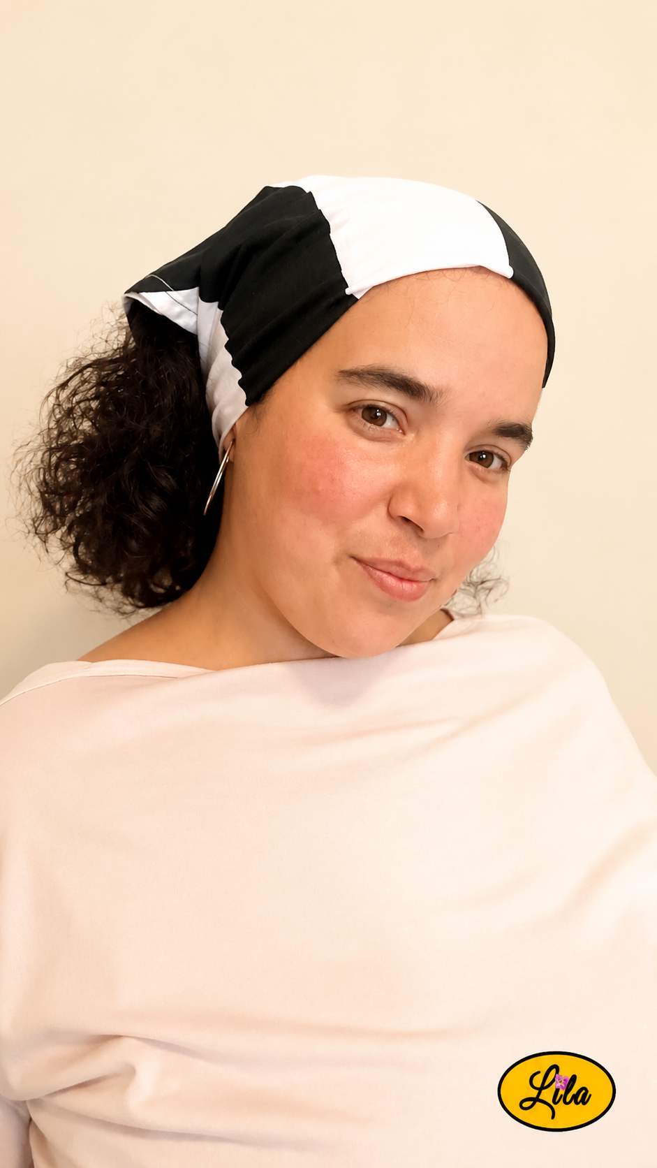 Bandana noir à larges rayures blanches porté dans les cheveux par une femme de profil droit avec les cheveux lâchés sous le bandana style chic et intemporel