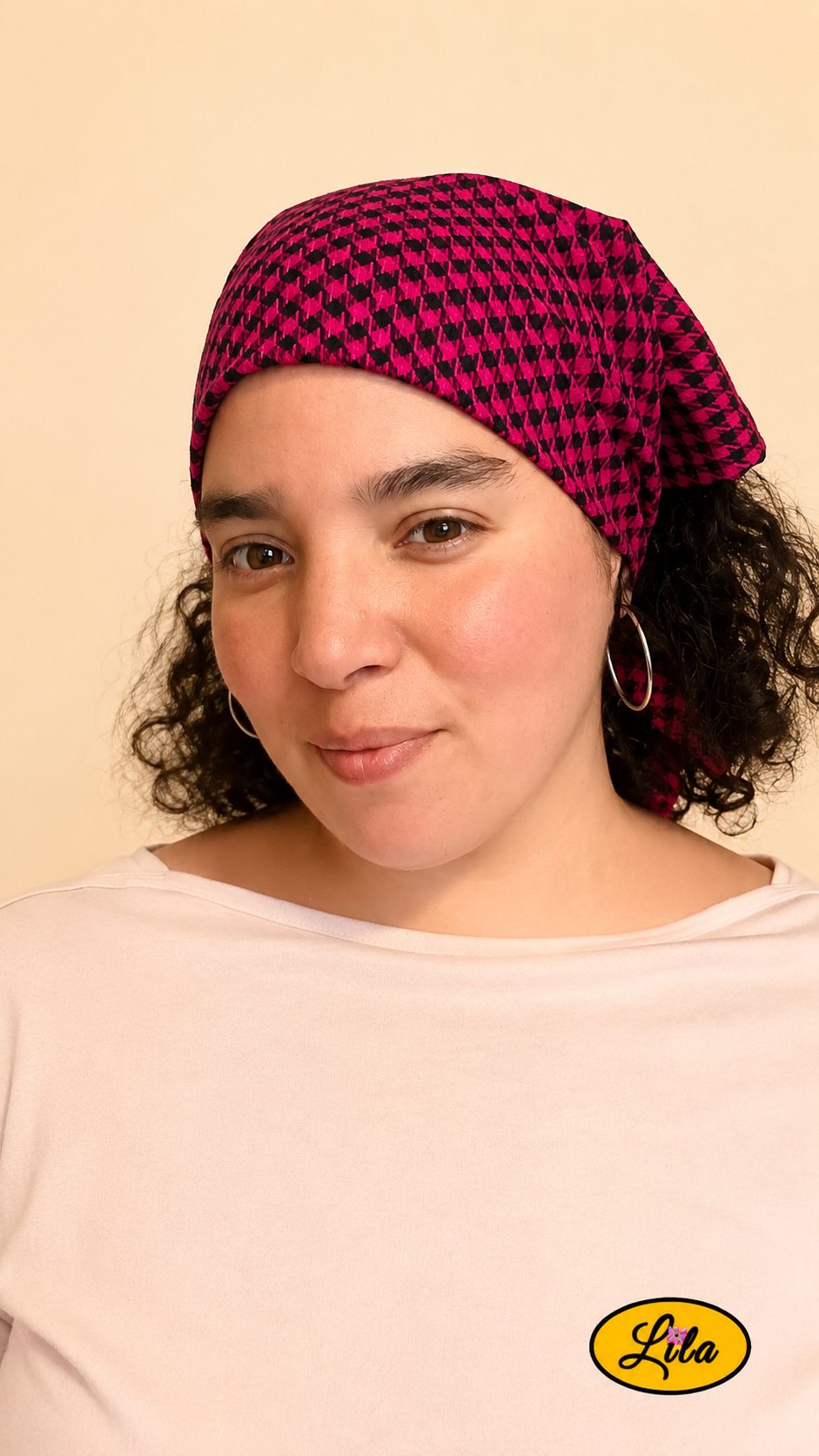 Bandana rose et noir à carreaux porté dans les cheveux par une femme de profil avec les cheveux lâchés visibles entre le bandana et la nuque style féminin et artisanal