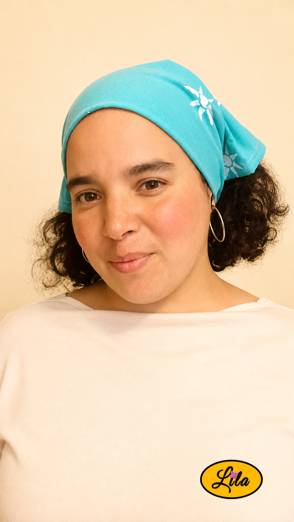 Bandana vert d'eau à motifs soleils porté dans les cheveux par une femme de profil gauche avec les cheveux lâchés sous le bandana style bohème et estival