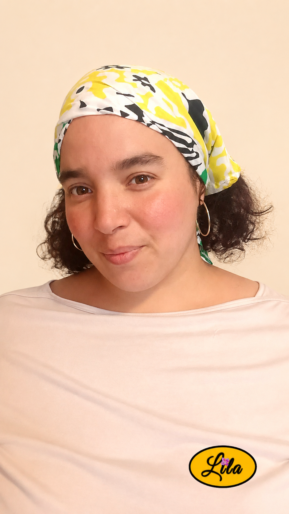 Bandana vert et jaune à motifs floraux vintage porté dans les cheveux par une femme de profil gauche avec les cheveux lâchés sous le bandana, côté jaune visible, style rétro et féminin
