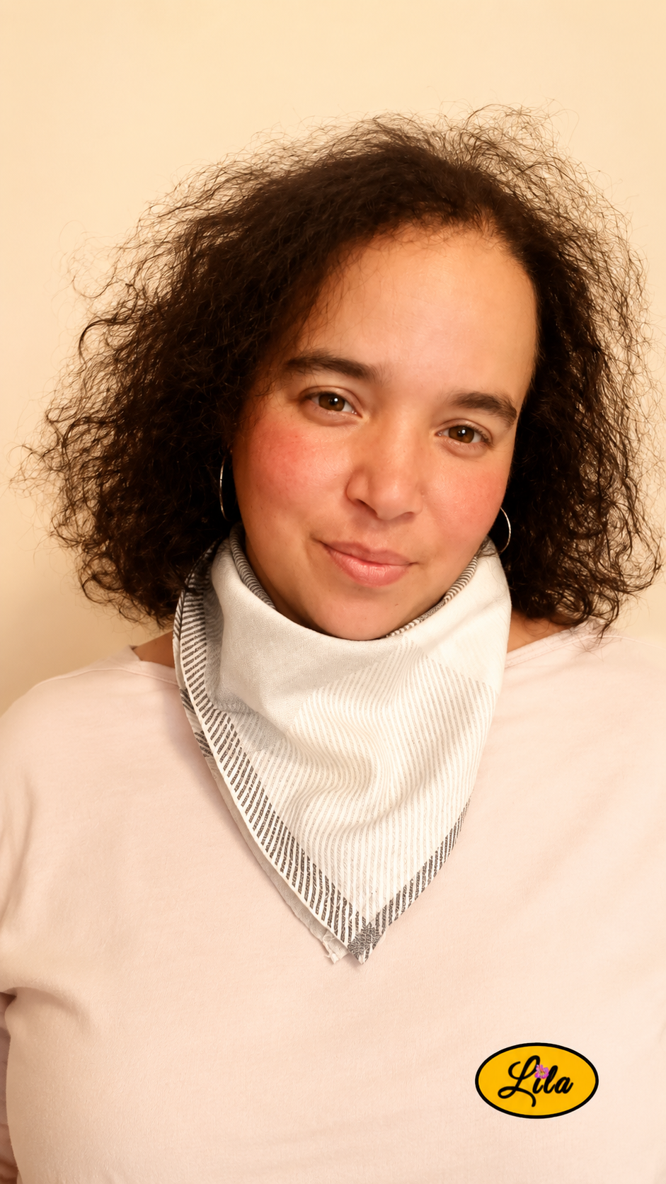 Bandana vintage à rayures brunes et grises porté autour du cou par une femme de face aux cheveux lâchés avec la tête légèrement inclinée et un léger sourire style rétro et tendance