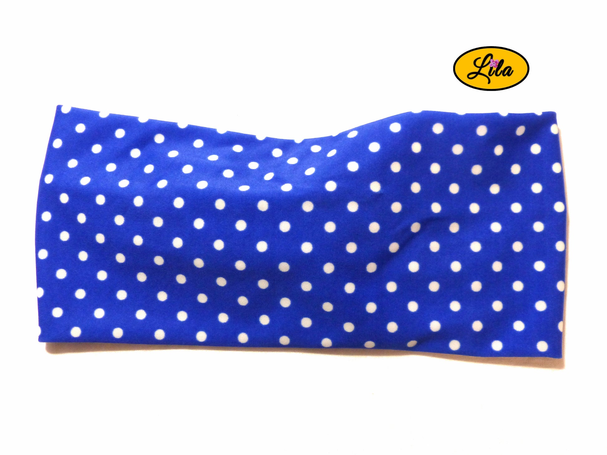 Bandeau en tissu bleu à pois blancs vu de dos sur fond blanc style pin-up et tendance