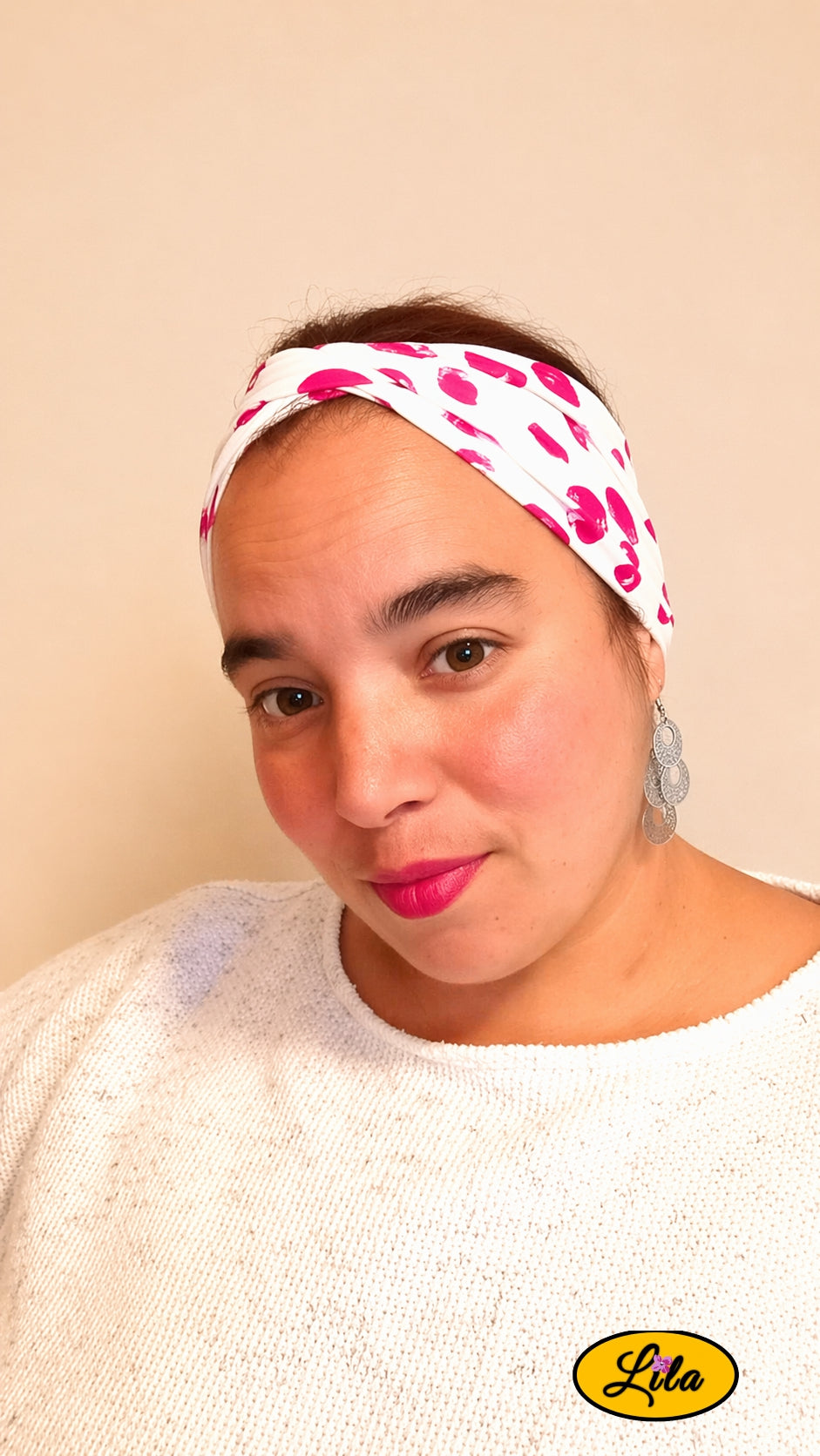 Bandeau en tissu blanc à ronds roses porté profil gauche avec noeud au-dessus de la tête