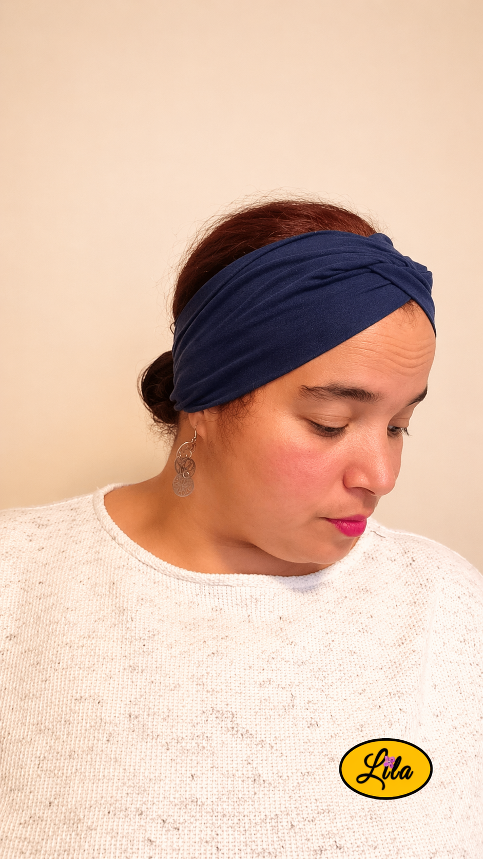 Bandeau en tissu bleu foncé porté profil droit avec noeud au-dessus regard vers le bas