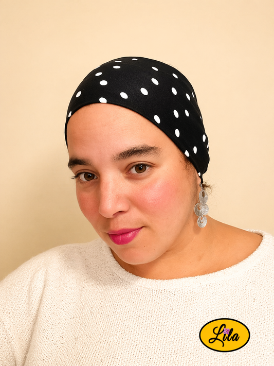Bandeau en tissu noir à pois blancs porté légèrement de profil gauche style vintage