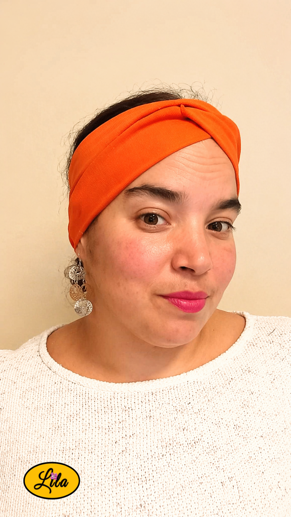 Bandeau en tissu orange porté de face tête légèrement inclinée vers la droite avec noeud au-dessus