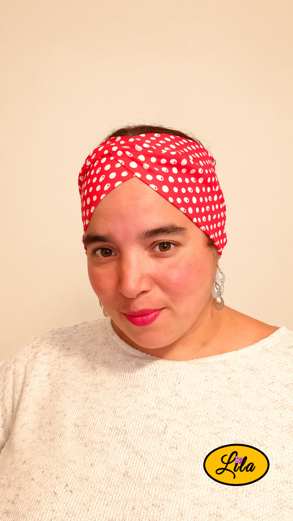 Bandeau en tissu rose à pois blancs porté de face avec noeud au-dessus de la tête style féminin