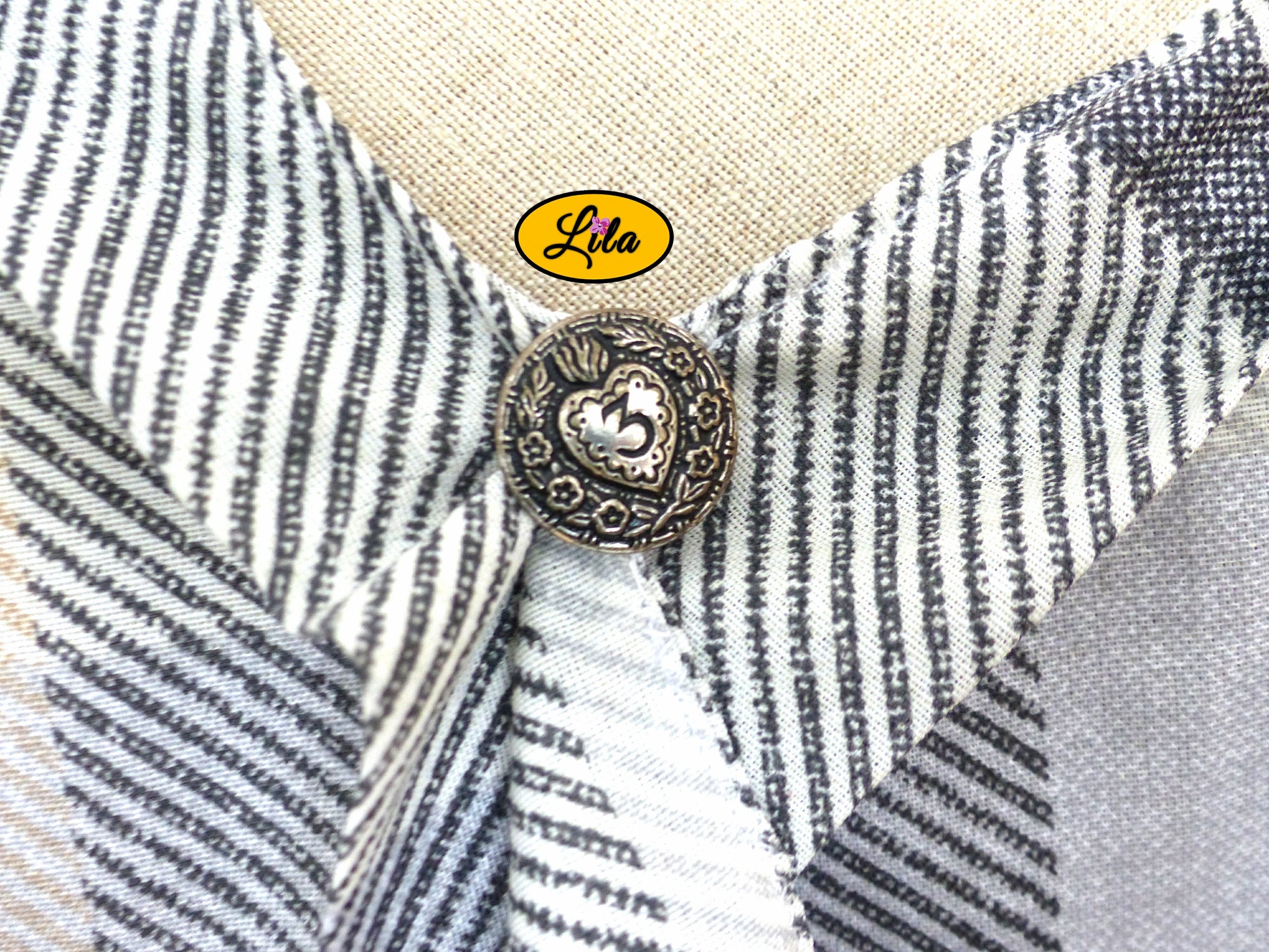 Zoom sur le décolleté croisé de la blouse Clara cousue à la main avec bouton décoratif argenté recyclé détail élégant et vintage