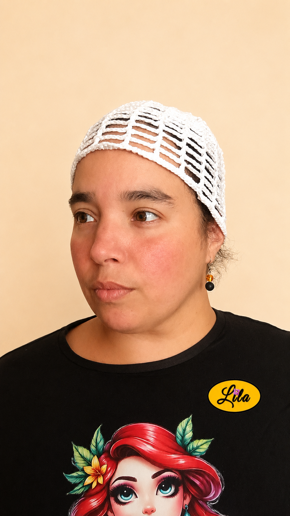 Bonnet d'été en crochet ajouré blanc porté par un mannequin de profil gauche avec les cheveux attachés mettant en valeur sa forme, son motif ajouré et son style artisanal