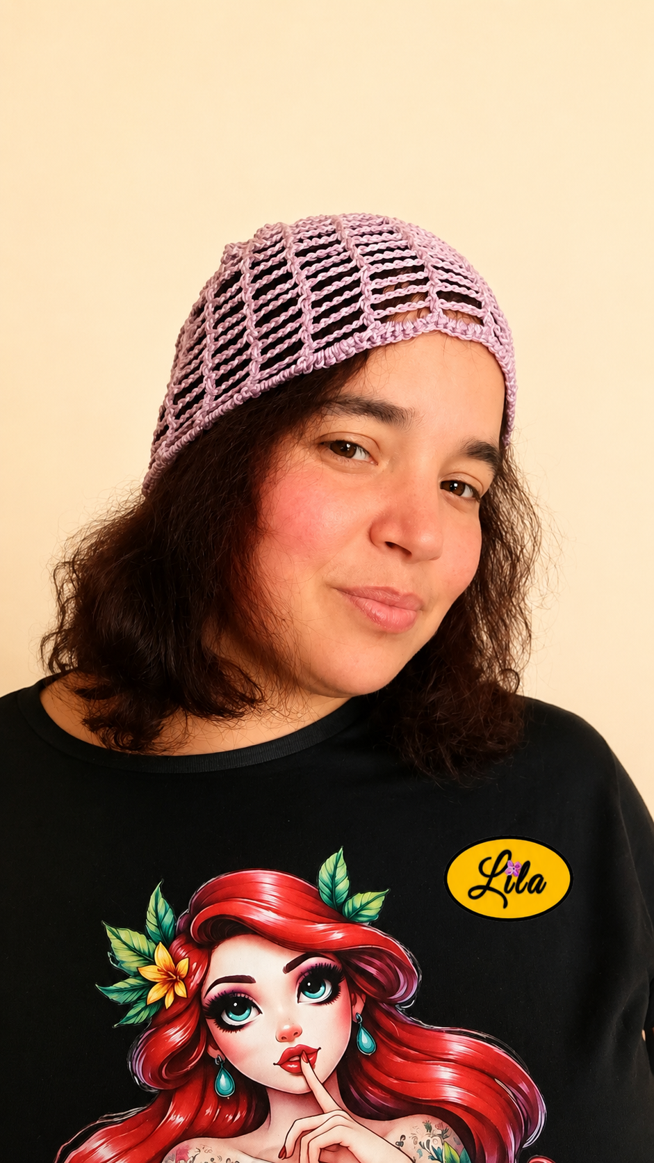 Bonnet d'été en crochet ajouré lilas porté par un mannequin légèrement de profil droit avec les cheveux lâchés, mettant en valeur son style bohème, sa texture ajourée et son crochet fait main