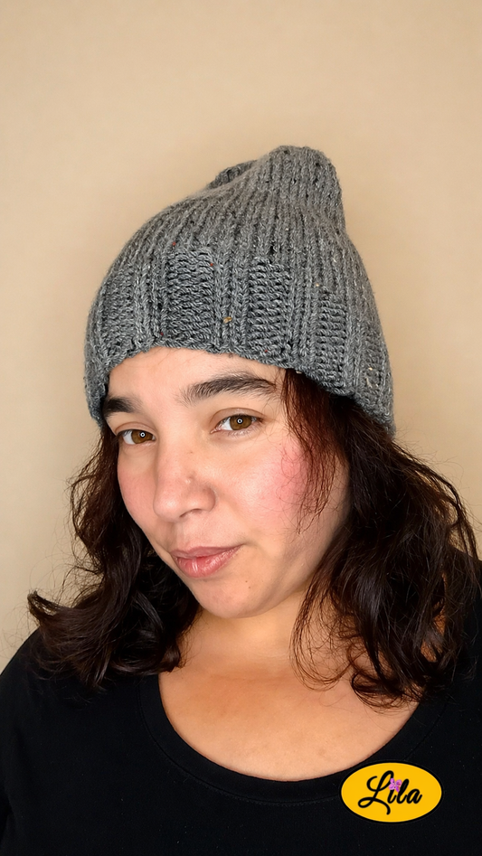 Bonnet en laine gris porté de face tête légèrement inclinée vers la gauche avec cheveux lâchés style naturel