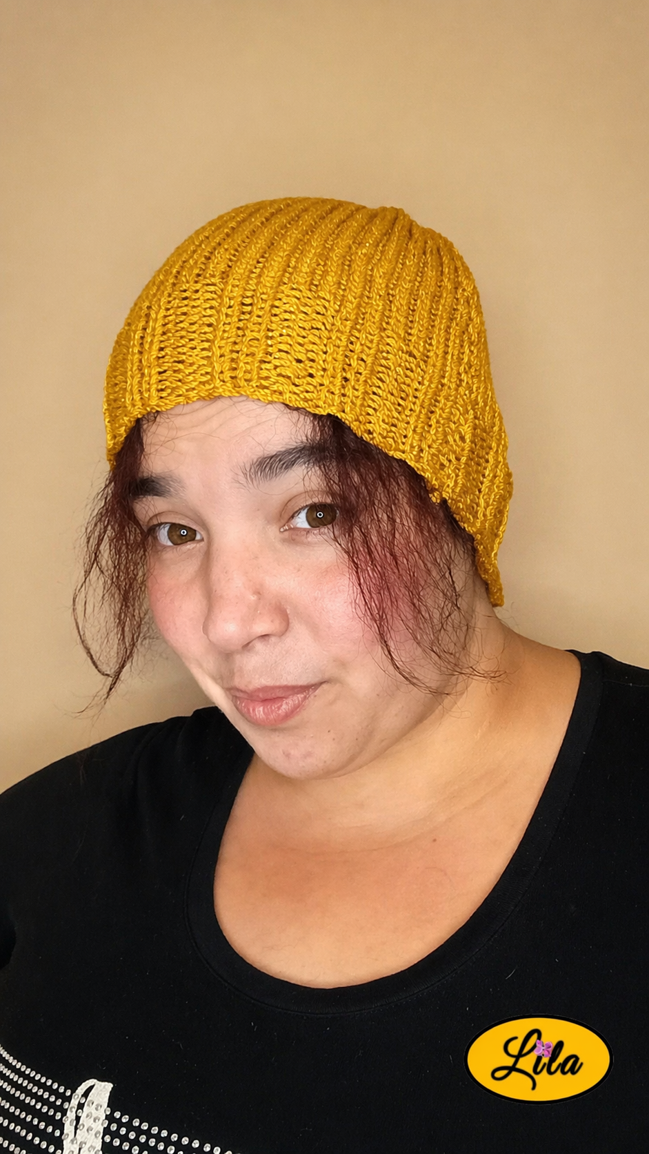 Bonnet en laine moutarde pailleté porté de face légèrement de profil gauche avec mèches de cheveux sur le devant