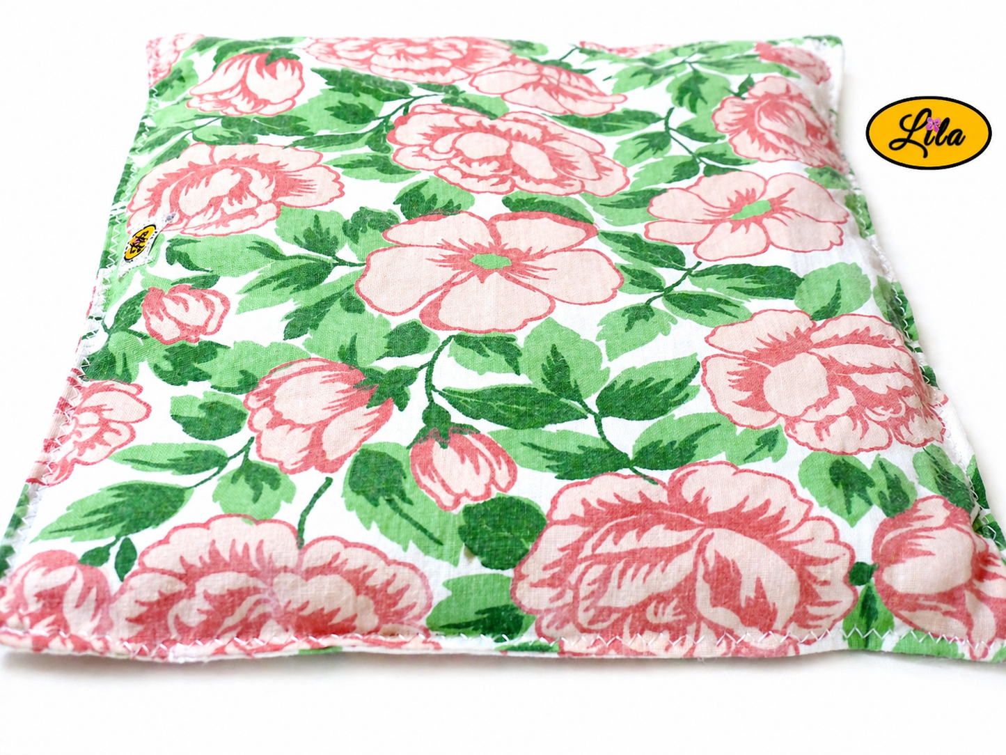 Bouillotte carrée fleurie réalisée dans un ancien drap de lit recyclé remplie de noyaux de cerise vue de face sur fond blanc style cocooning et bien-être