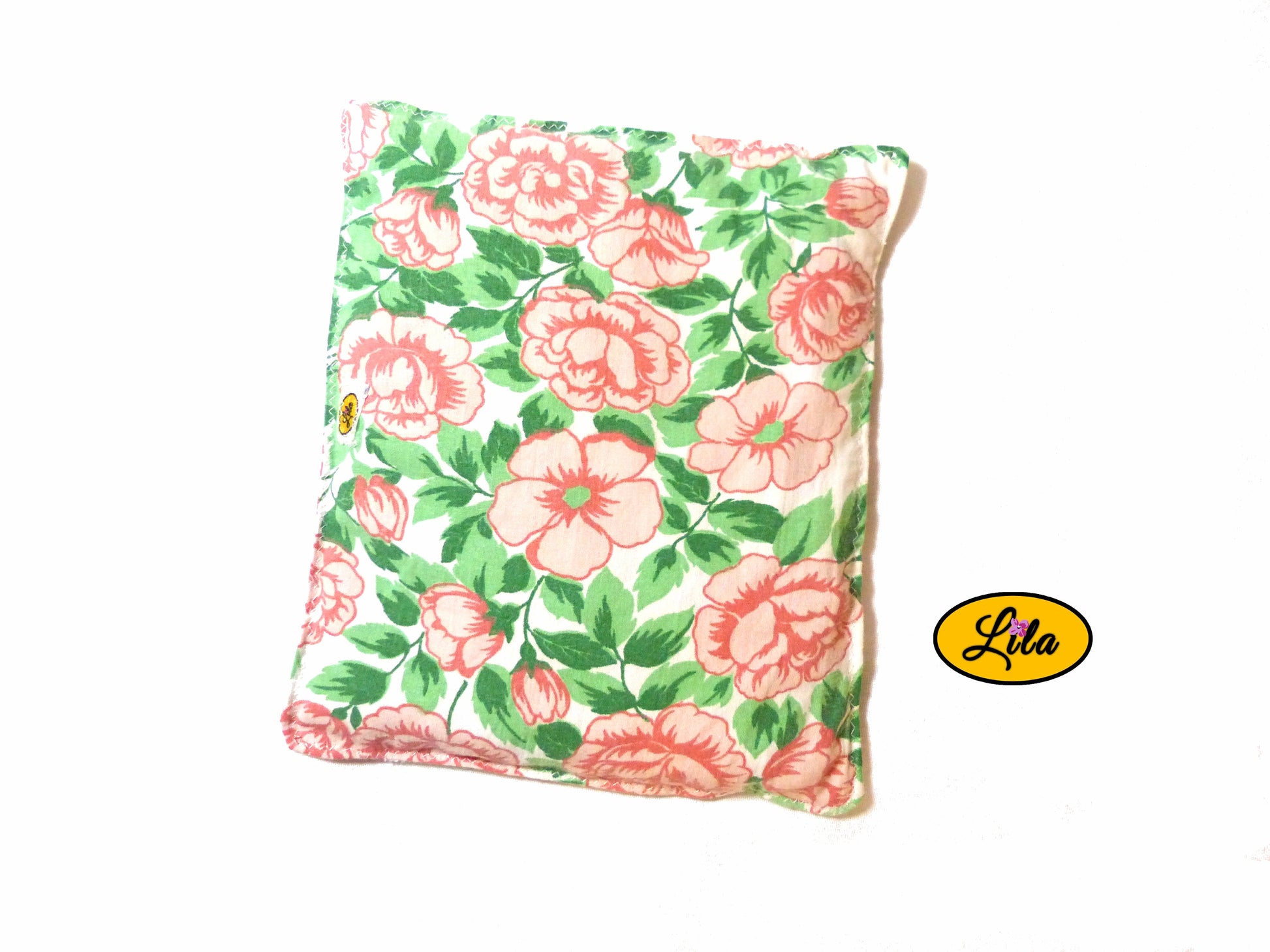 Bouillotte carrée fleurie réalisée dans un ancien drap de lit recyclé remplie de noyaux de cerise vue de haut sur fond blanc style naturel et artisanal