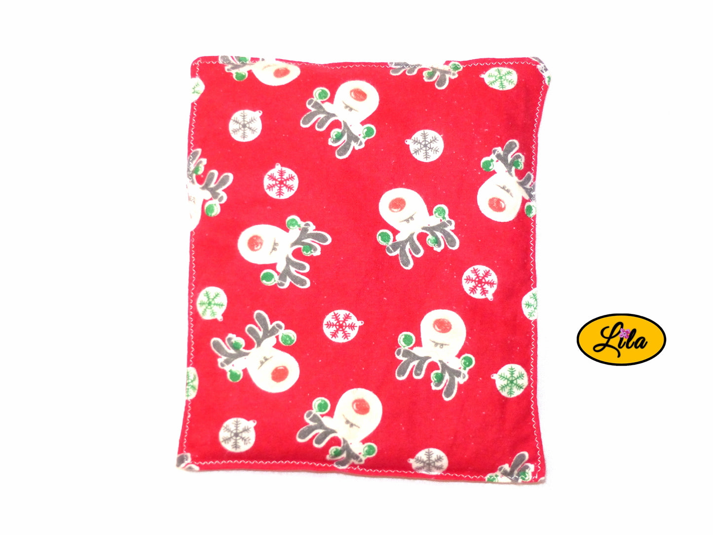Bouillotte motif rennes sur fond rouge réalisée dans un ancien pyjama recyclé remplie de noyaux de cerise vue de dos sur fond blanc style artisanal et hivernal