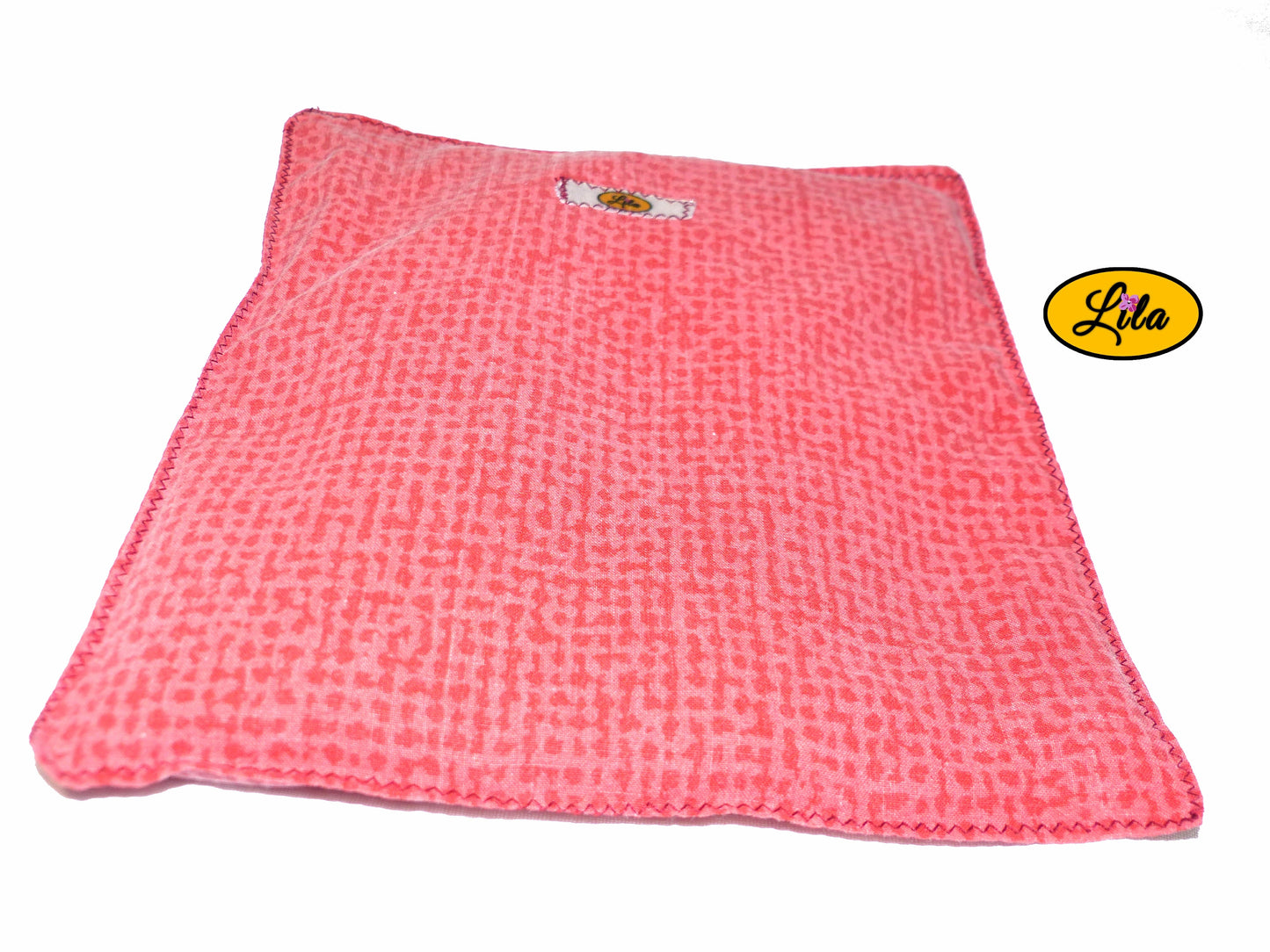 Bouillotte simple rouge et orange réalisée dans d’anciens draps de lit recyclés remplie de noyaux de cerise vue de face sur fond blanc style cocooning et bien-être