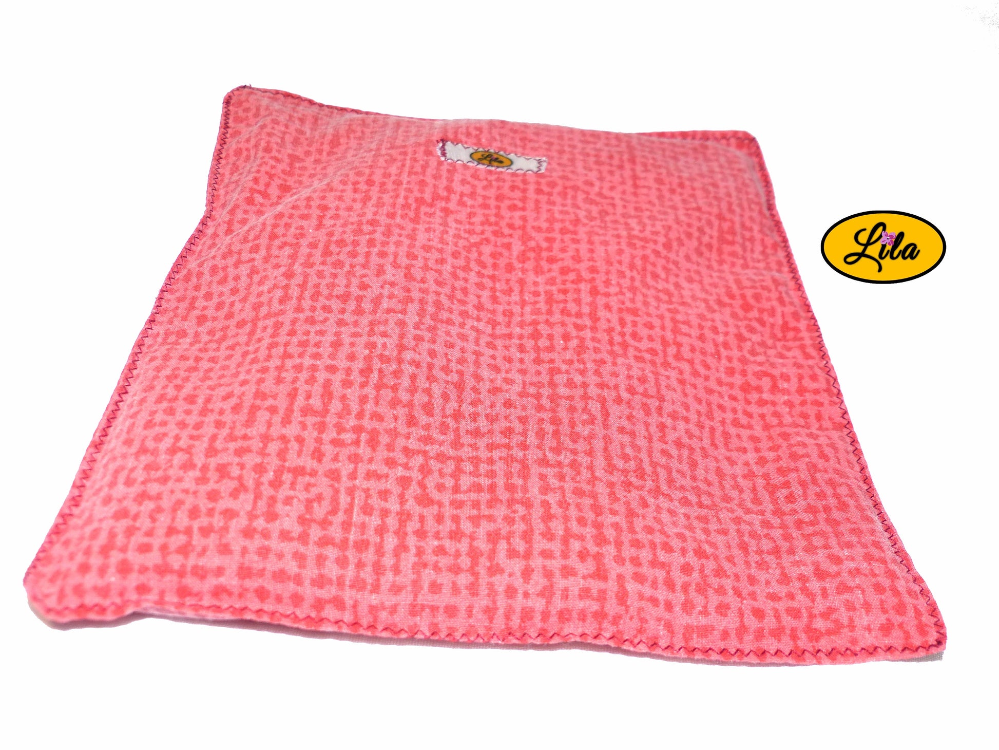 Bouillotte simple rouge et orange réalisée dans d’anciens draps de lit recyclés remplie de noyaux de cerise vue de face sur fond blanc style cocooning et bien-être