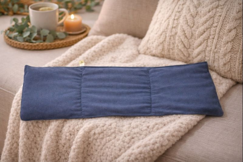 Bouillotte XL bleu marine à 3 compartiments mise en scène sur fauteuil style cocooning