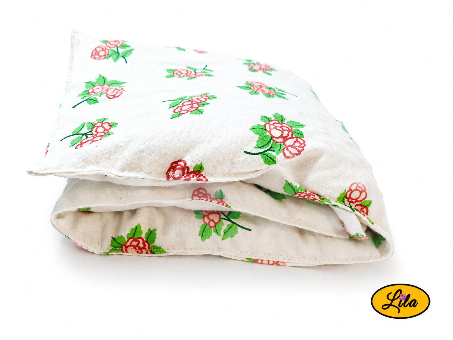 Bouillotte XL blanche fleurie réalisée dans un ancien drap de lit recyclé remplie de noyaux de cerise pliée en trois vue de face sur fond blanc style naturel et cocooning