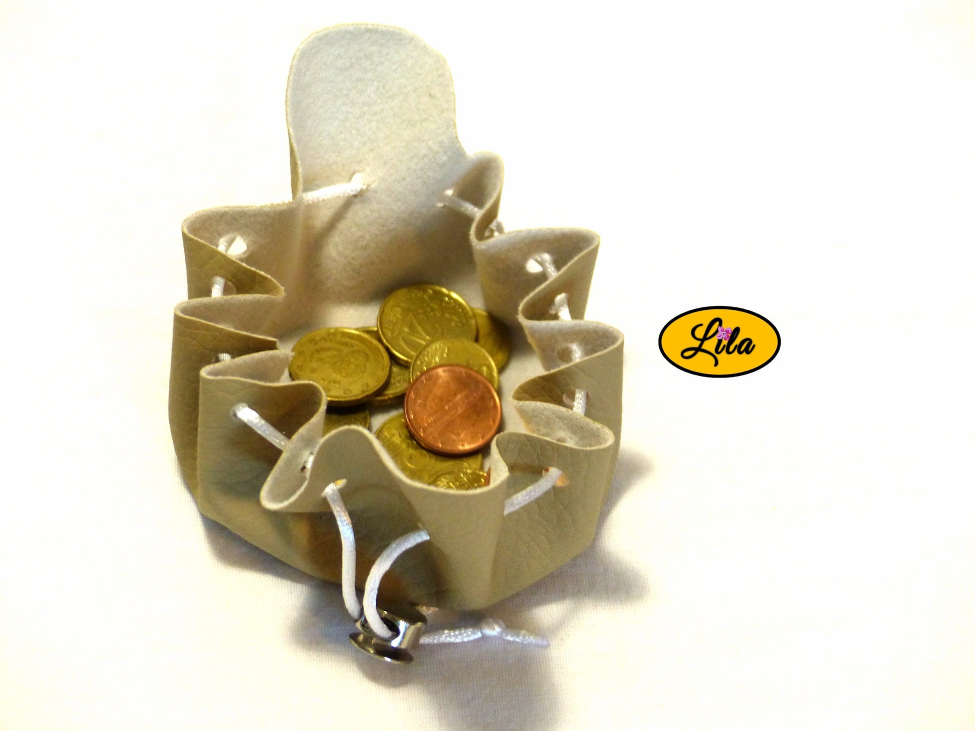 Bourse blanc crème en simili cuir ouverte vue de haut avec pièces de monnaie visibles et pince ronde argentée sur fond blanc style pratique et élégant